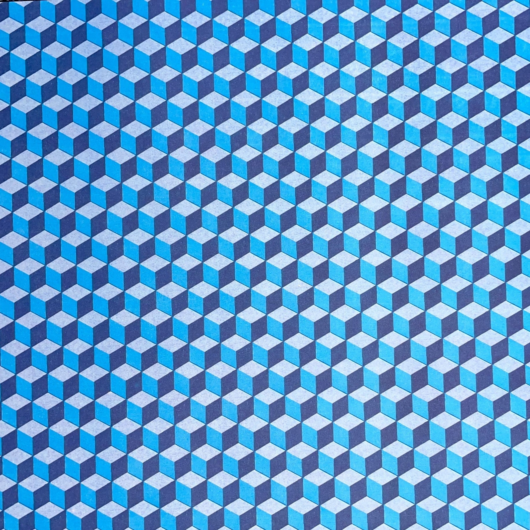 Italian patterned wrapping paper "Carta Varese" by Grafiche Tassotti.  A pattern of blue, aqua a navy geometric cubes with a 3D effect