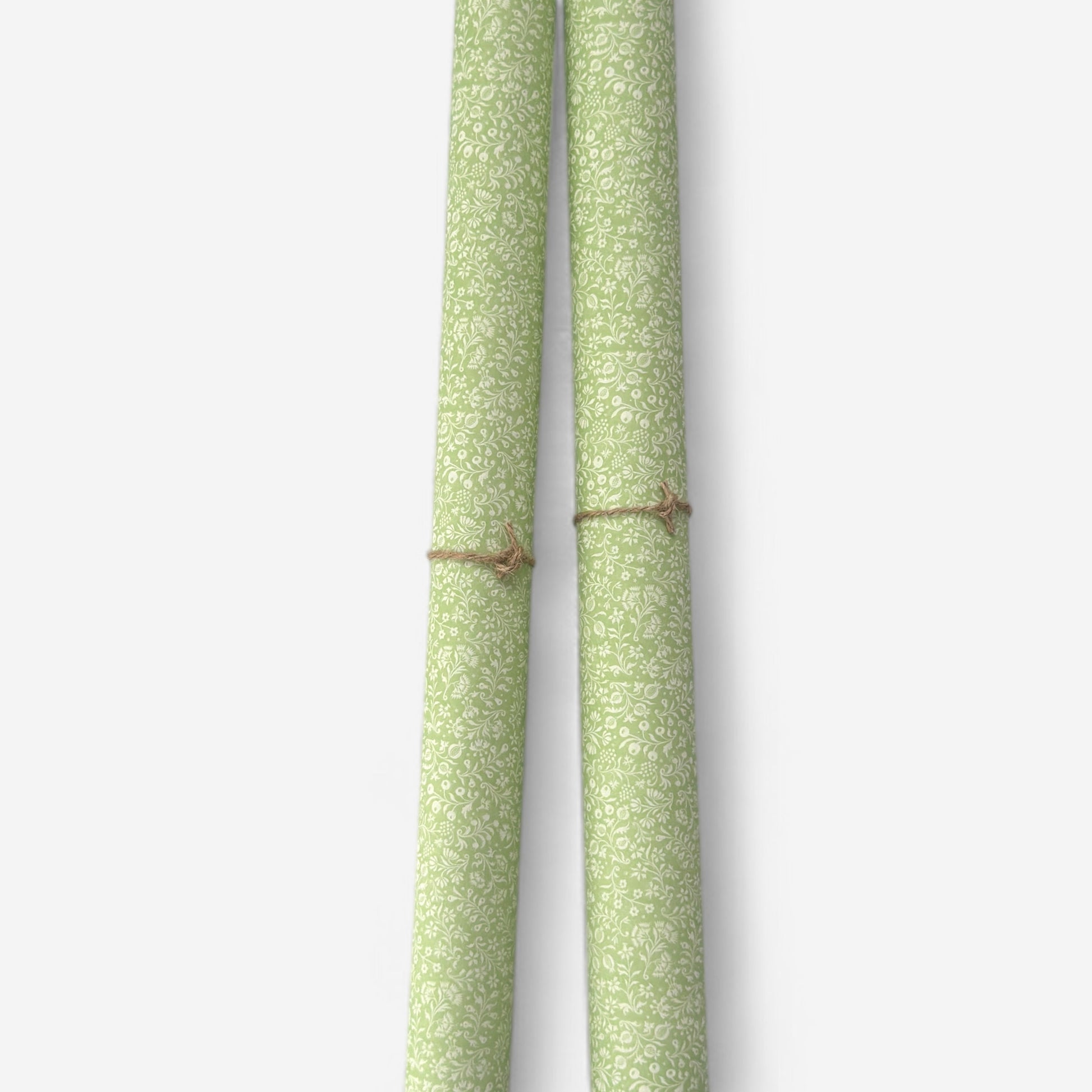 a sheet of italian wrapping paper with a delicate small floral design in light green and white. Pictured rolled
