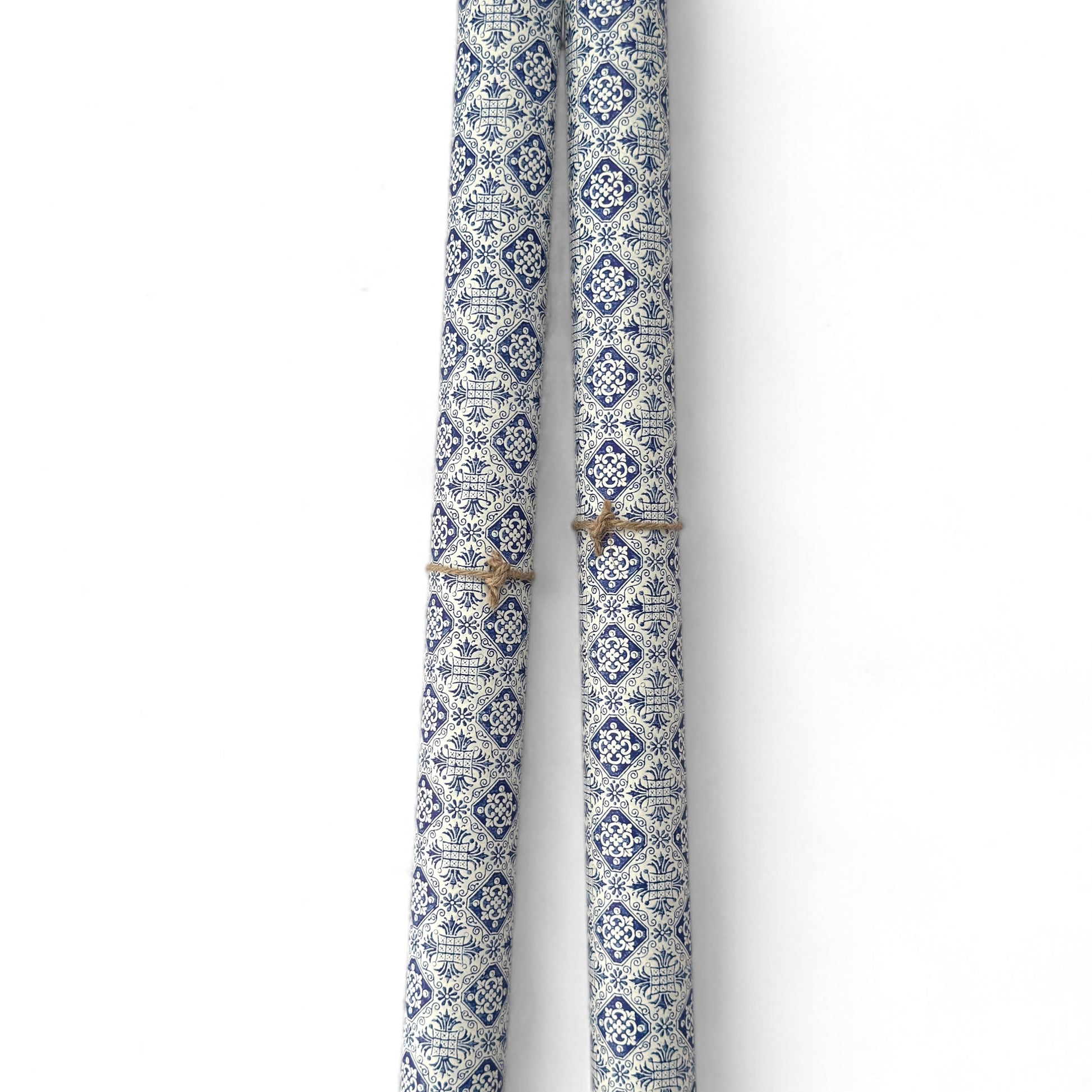 a sheet of italian wrapping paper with a blue block print repeat stamp pattern on white. Pictured rolled