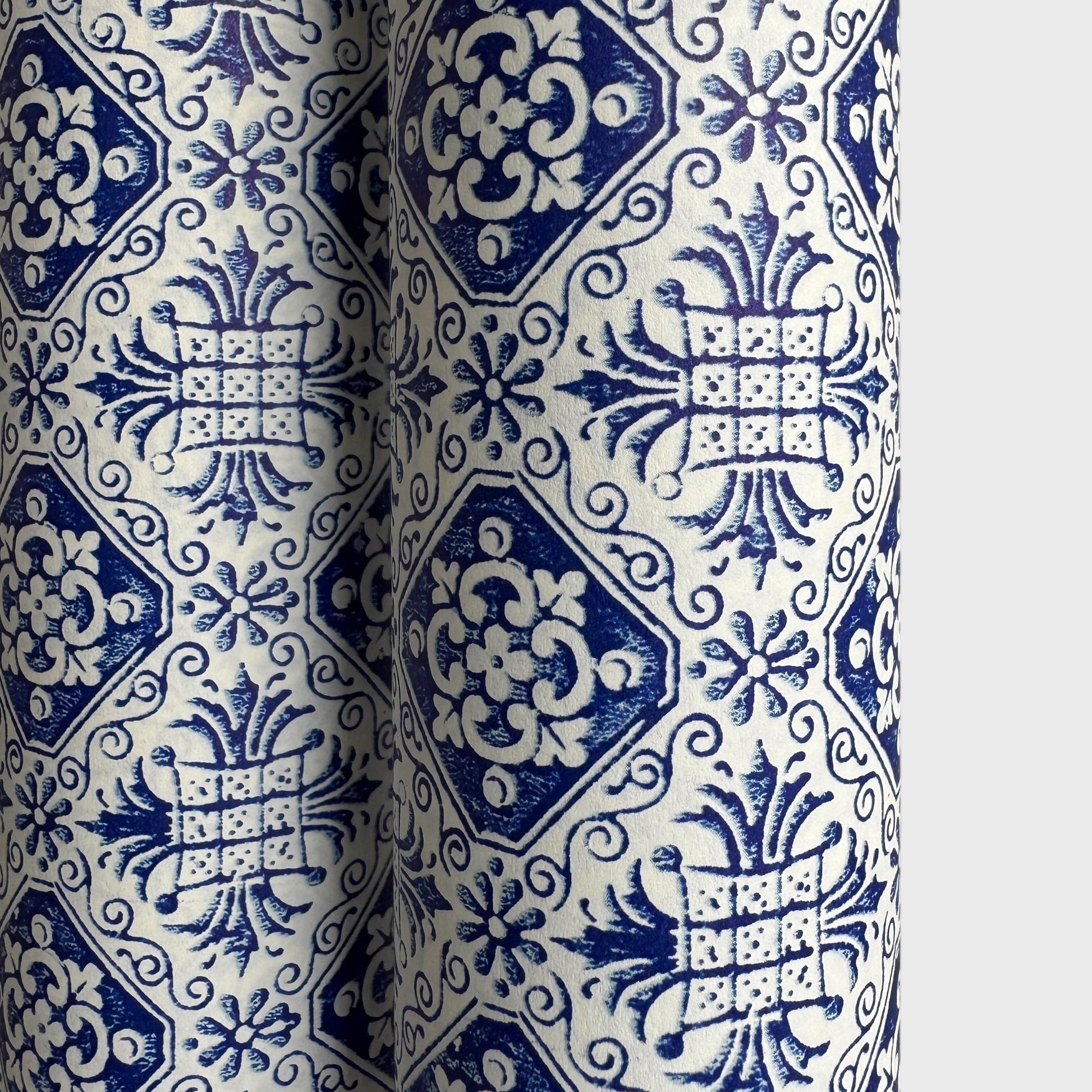 a sheet of italian wrapping paper with a blue block print repeat stamp pattern on white.