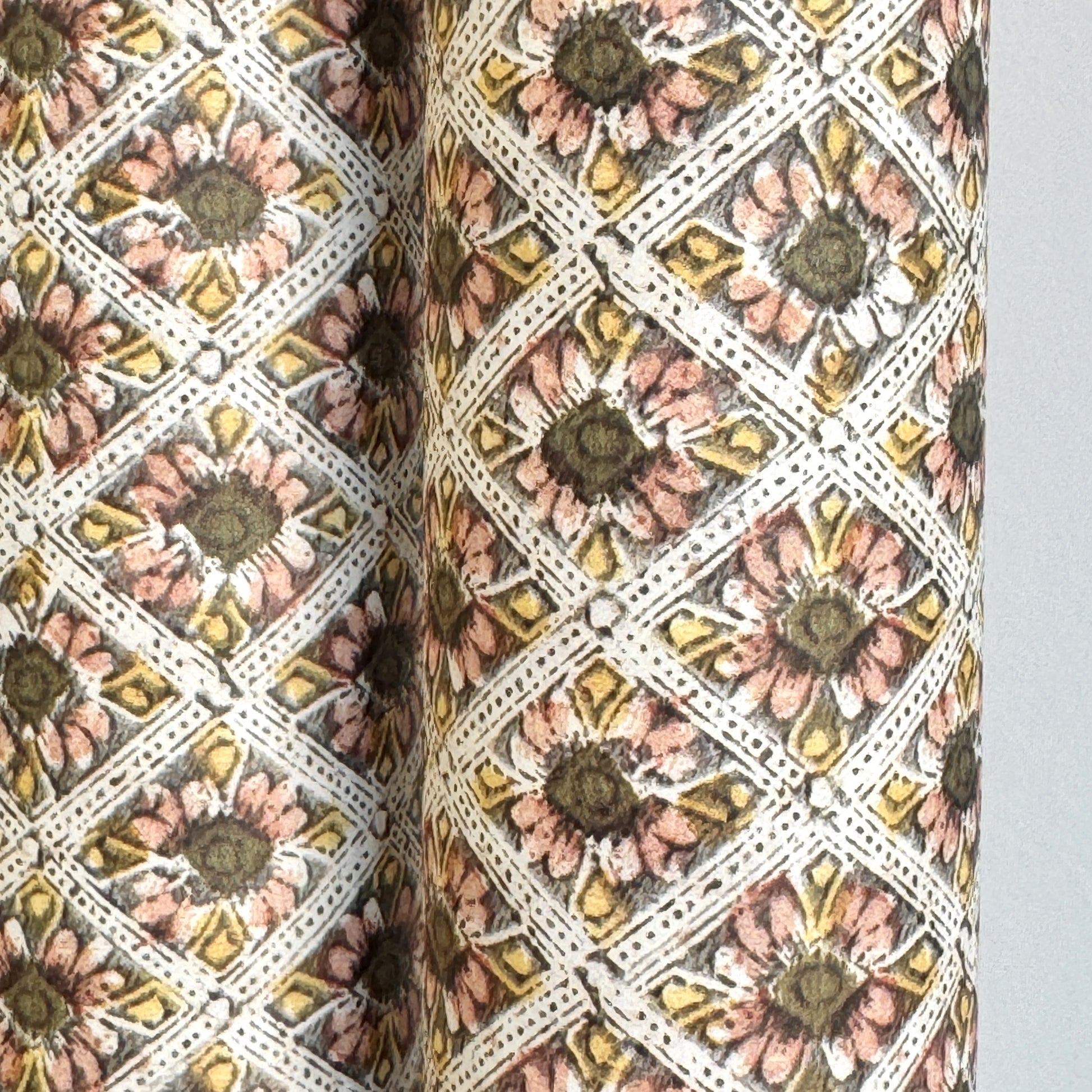 a sheet of italian wrapping paper with little flowers in a diamond grid in soft olive, pink and yellow