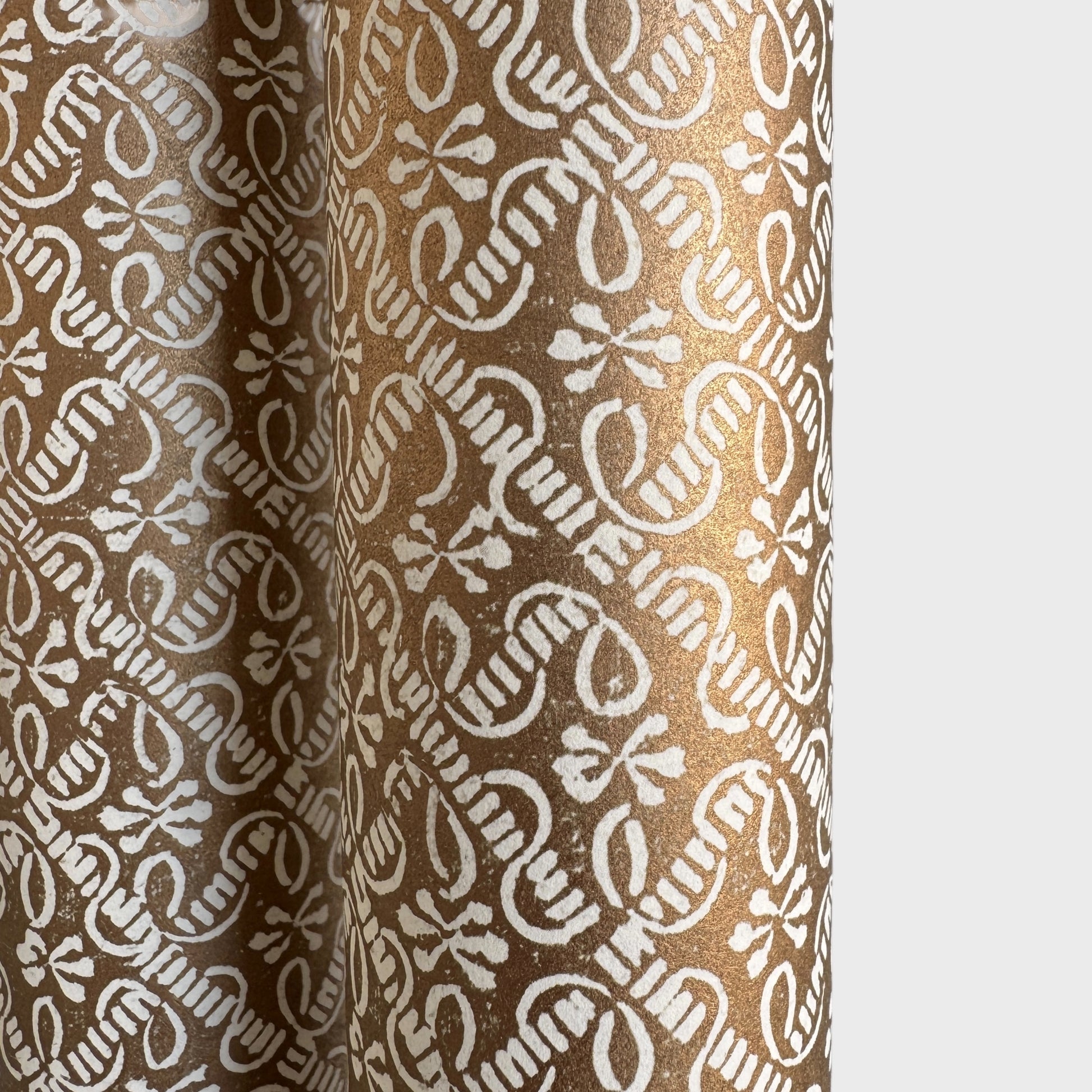 a sheet of italian wrapping paper with a decorative diamond grid in bronze gold on white