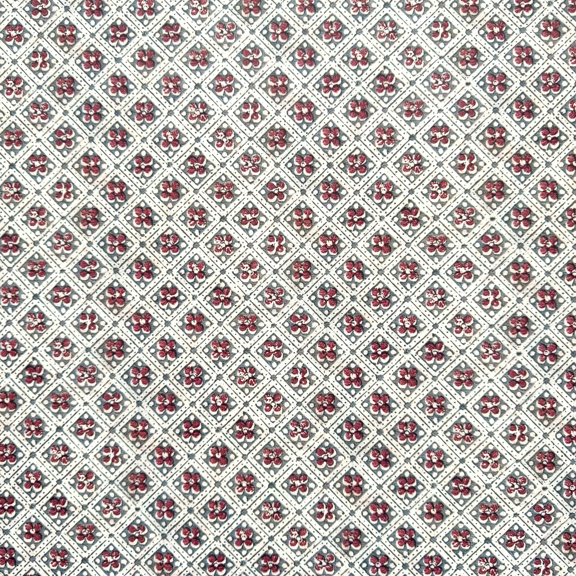a sheet of italian wrapping paper with a little red flower in a diamond grid design in green