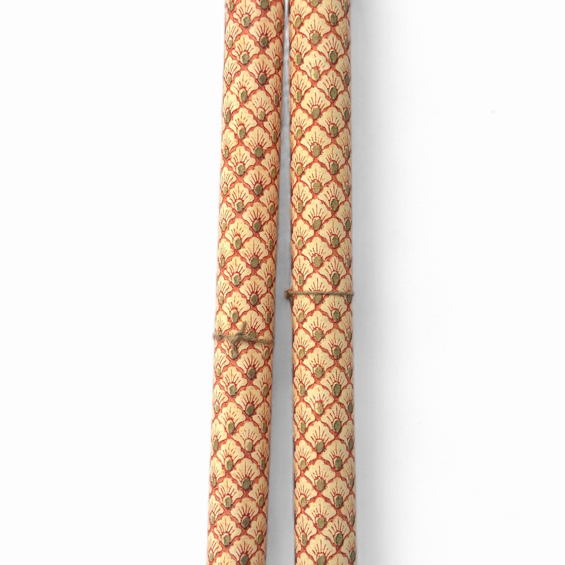 a sheet of italian wrapping paper with a shell repeat pattern in soft coral, cream and olive green. Pictured rolled