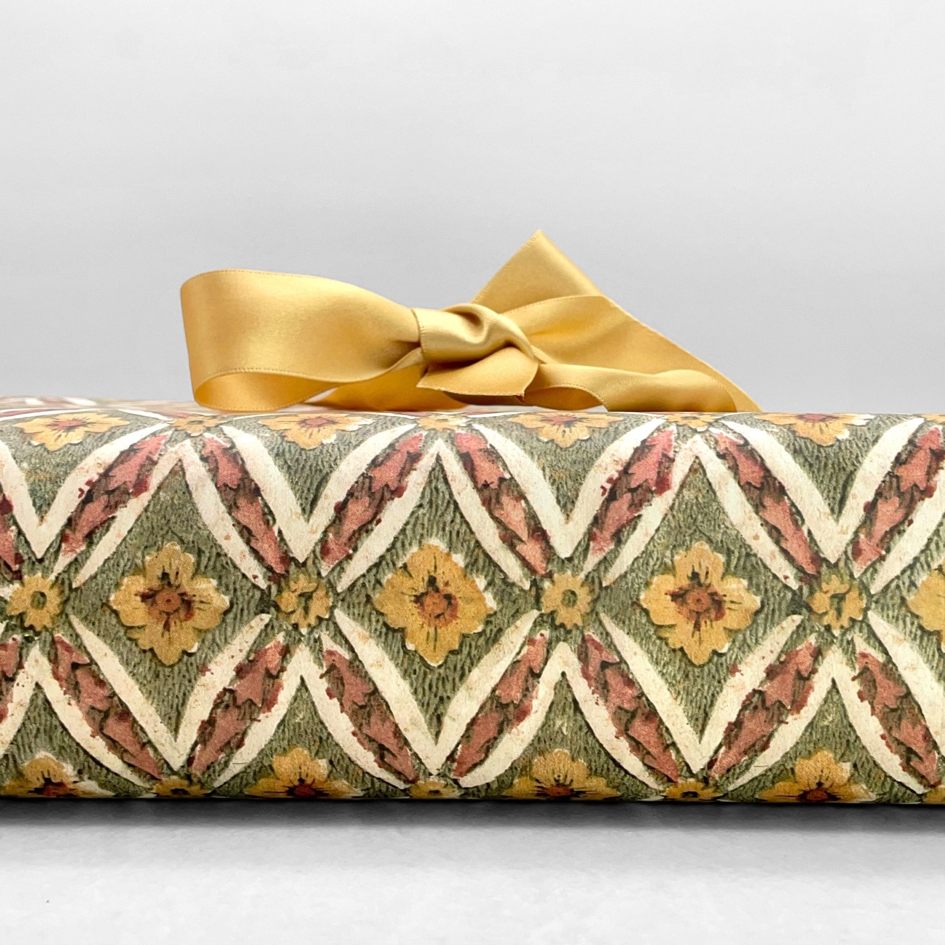 italian Remondini patterned wrapping paper by Tassotti. a repeat diamond pattern with flowers in sage green, soft peach and yellow on white background
