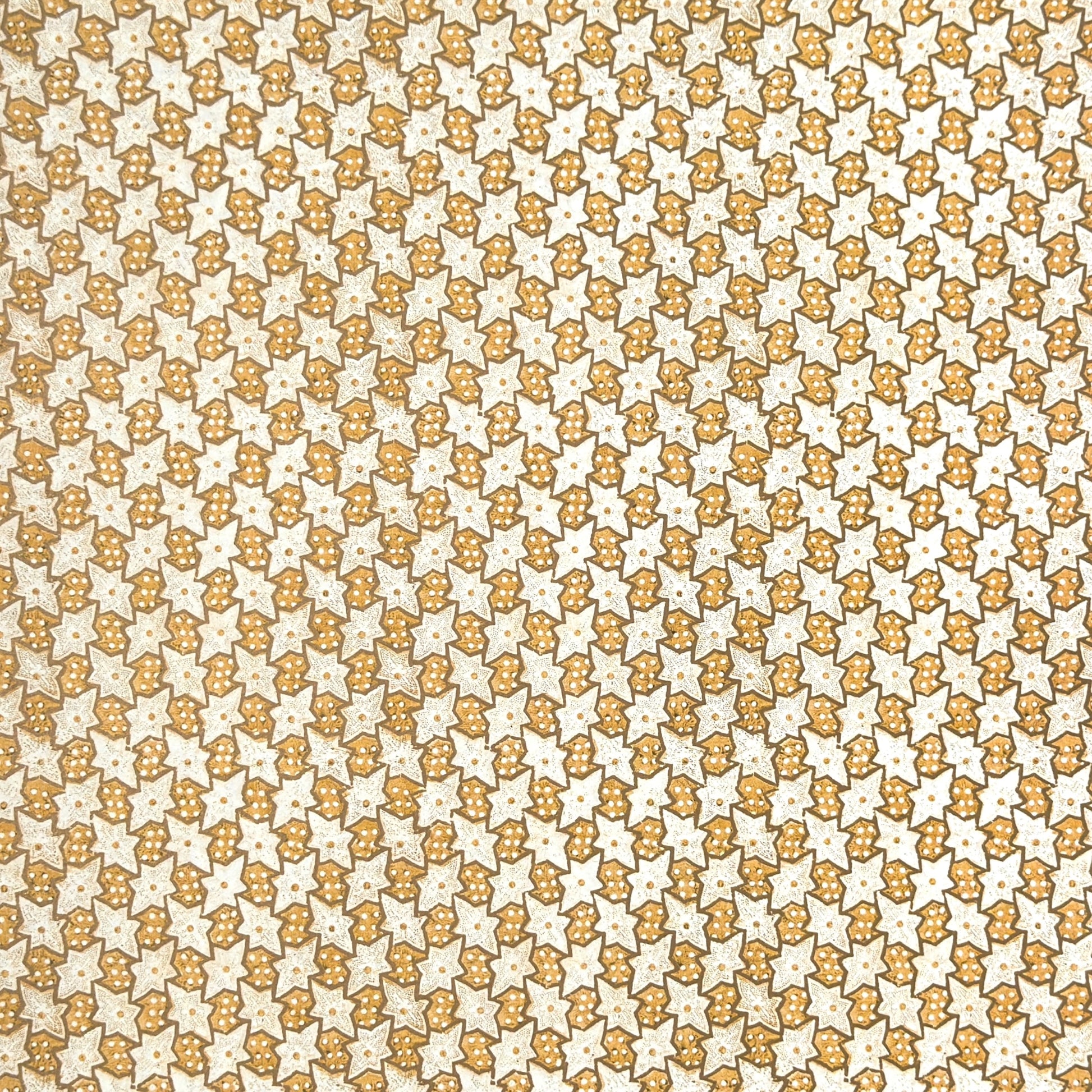 a sheet of italian wrapping paper with a star pattern in yellow, gold and white.