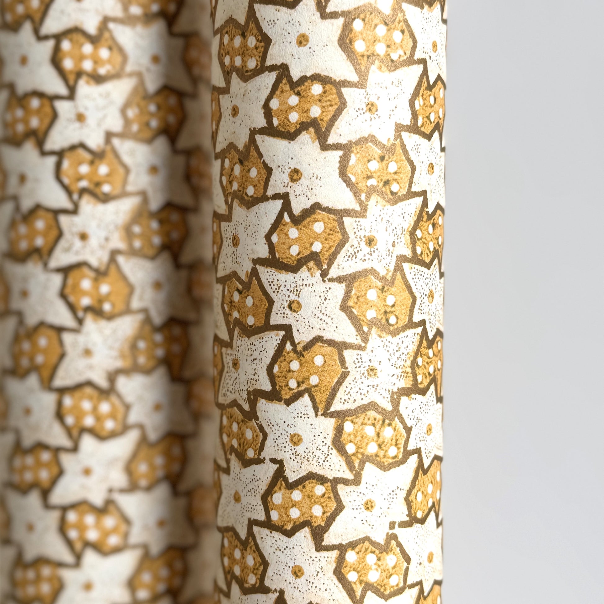 a sheet of italian wrapping paper with a star pattern in yellow, gold and white. Close up