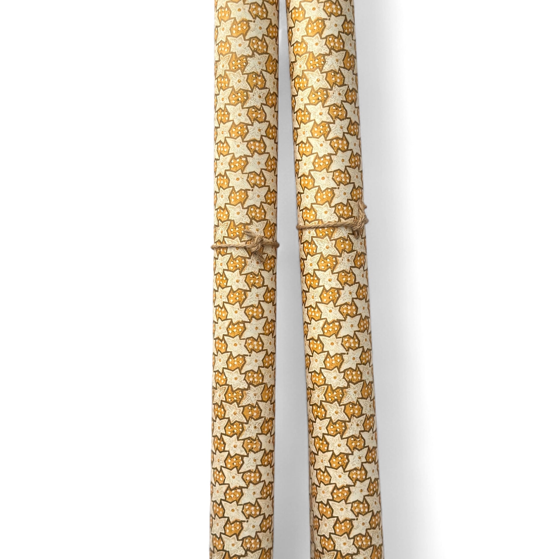 a sheet of italian wrapping paper with a star pattern in yellow, gold and white. Pictured rolled