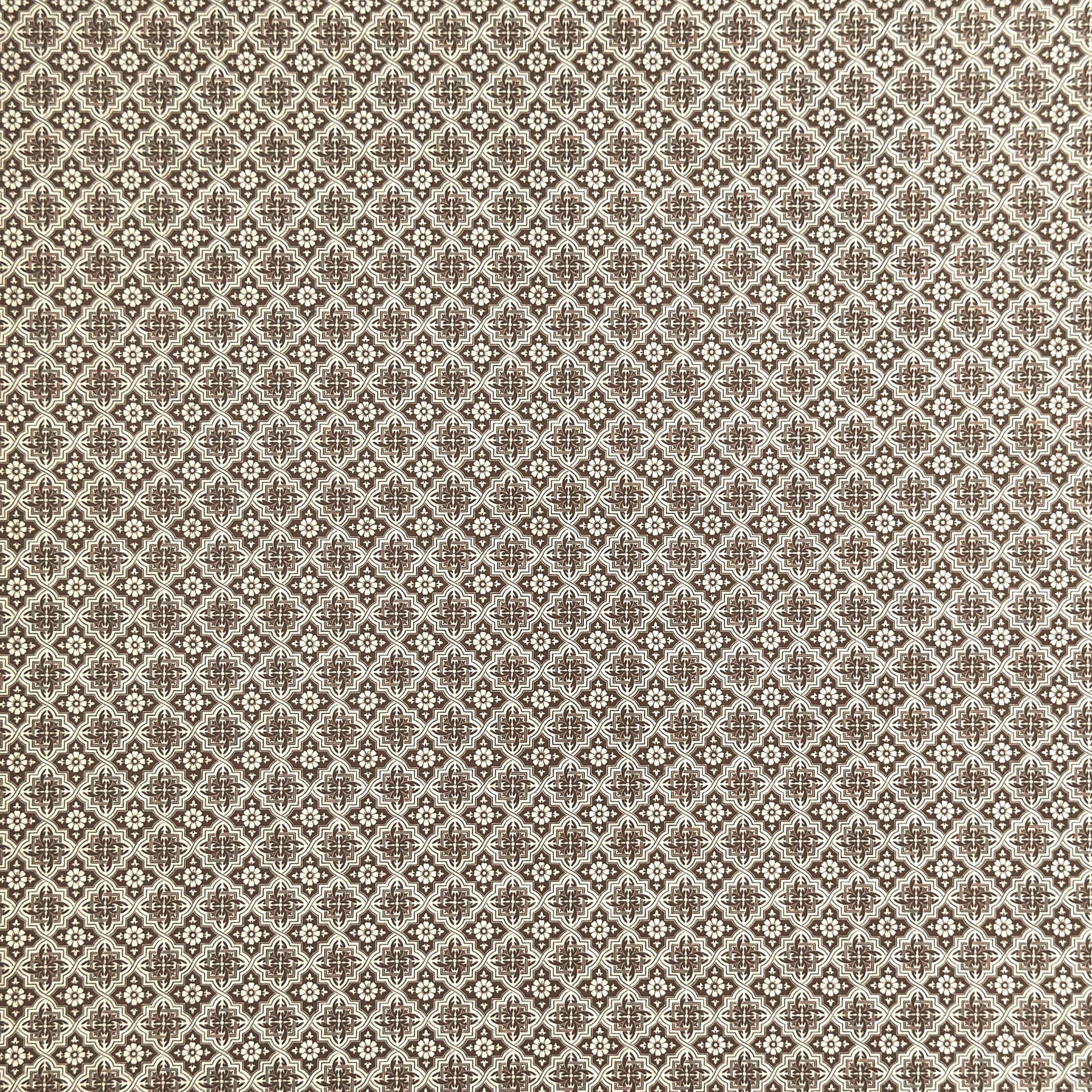 a sheet of italian wrapping paper with a small repeat geometric - floral pattern in brown and white
