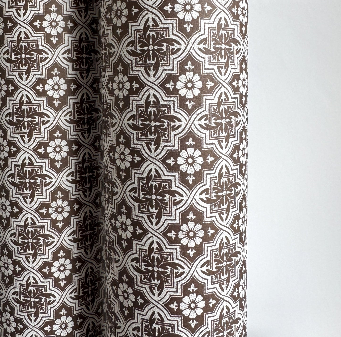 a sheet of italian wrapping paper with a small repeat geometric - floral pattern in brown and white