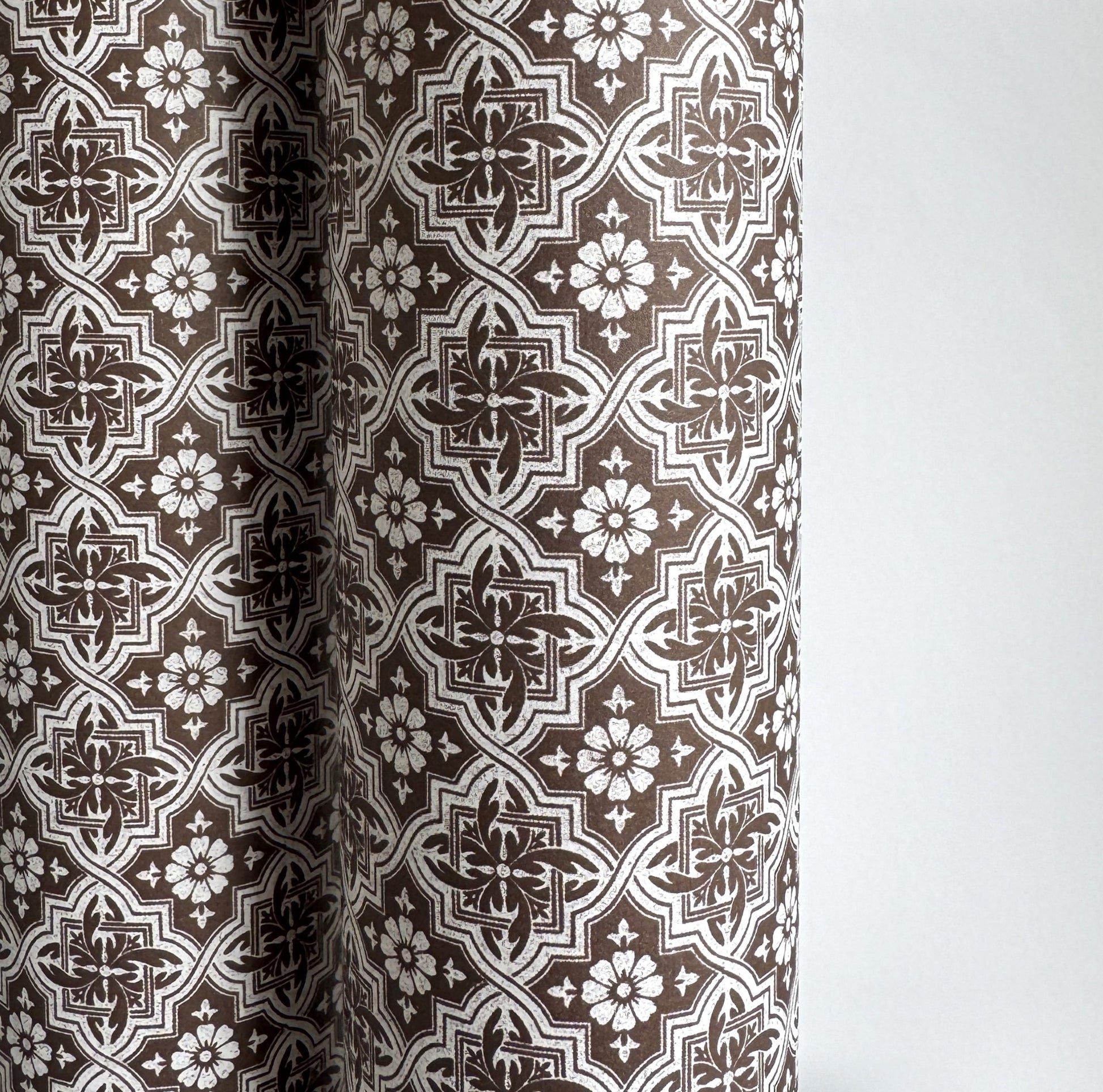 a sheet of italian wrapping paper with a small repeat geometric - floral pattern in brown and white