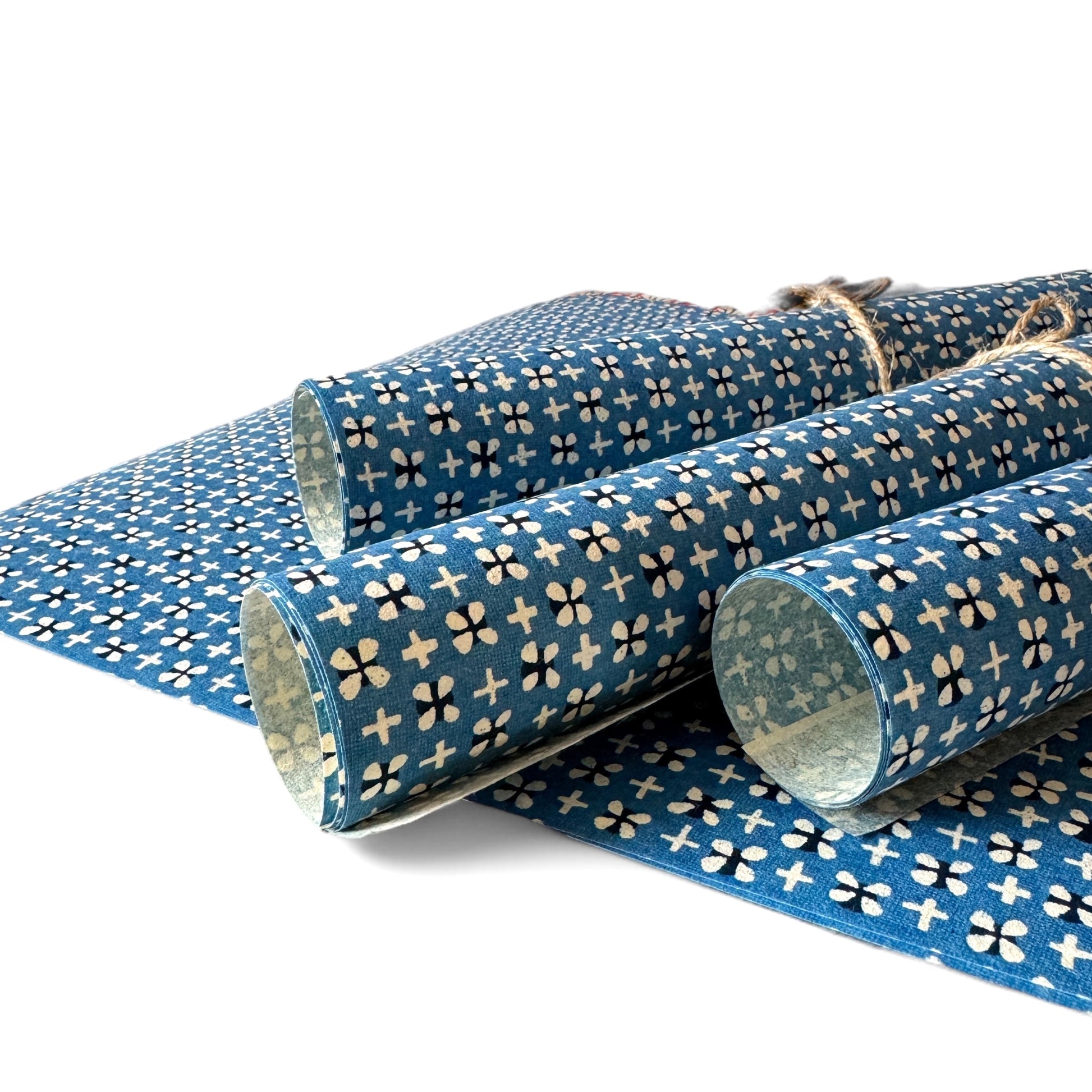 vintage katazome-shi stencil-dyed small papers from Japan. Cerulean blue paper with tiny motifs in cream and black. Pictured rolled.