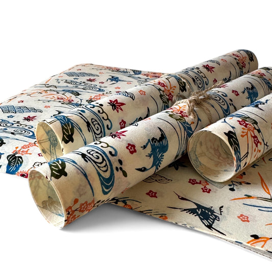 vintage katazome-shi stencil-dyed small papers from Japan. Cream paper with Japanese cranes in red, blue and green. Pictured rolled.