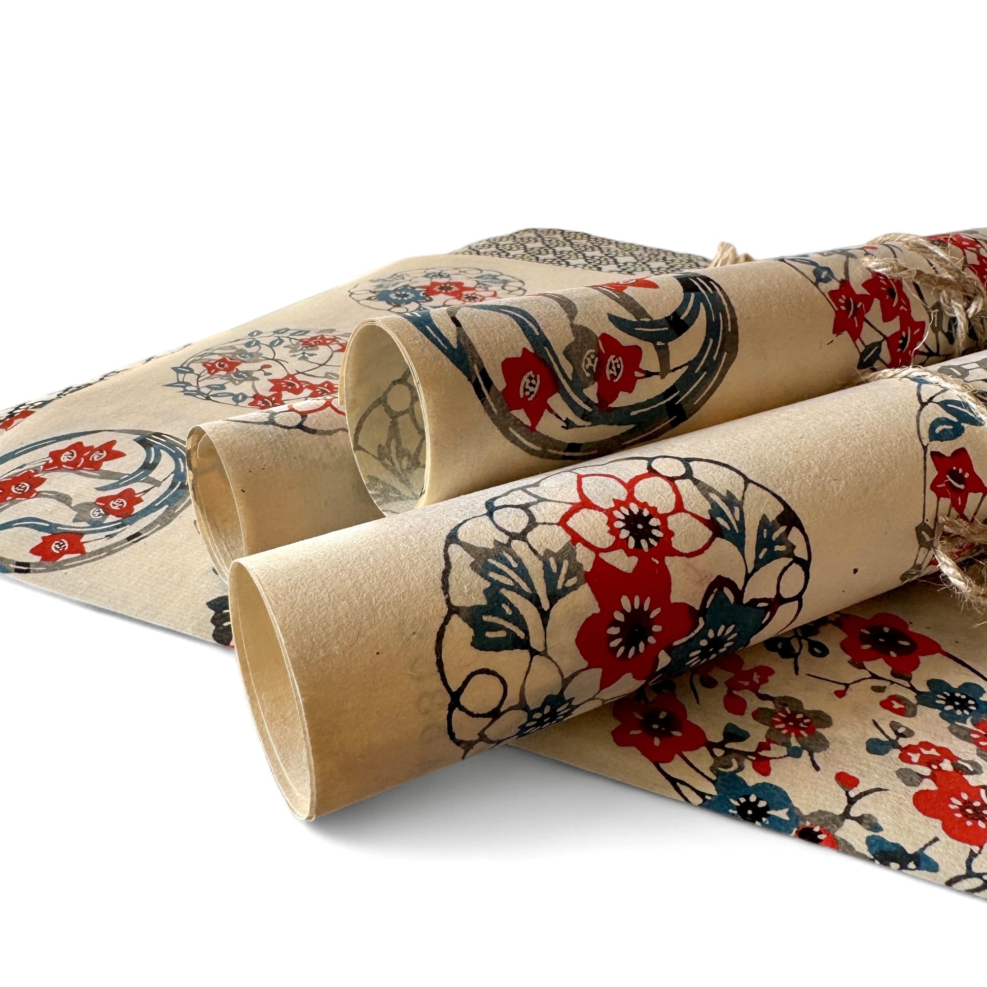 vintage katazome-shi stencil-dyed small papers from Japan. Cream paper with Japanese circle motifs in red, blue and green. Pictured rolled.