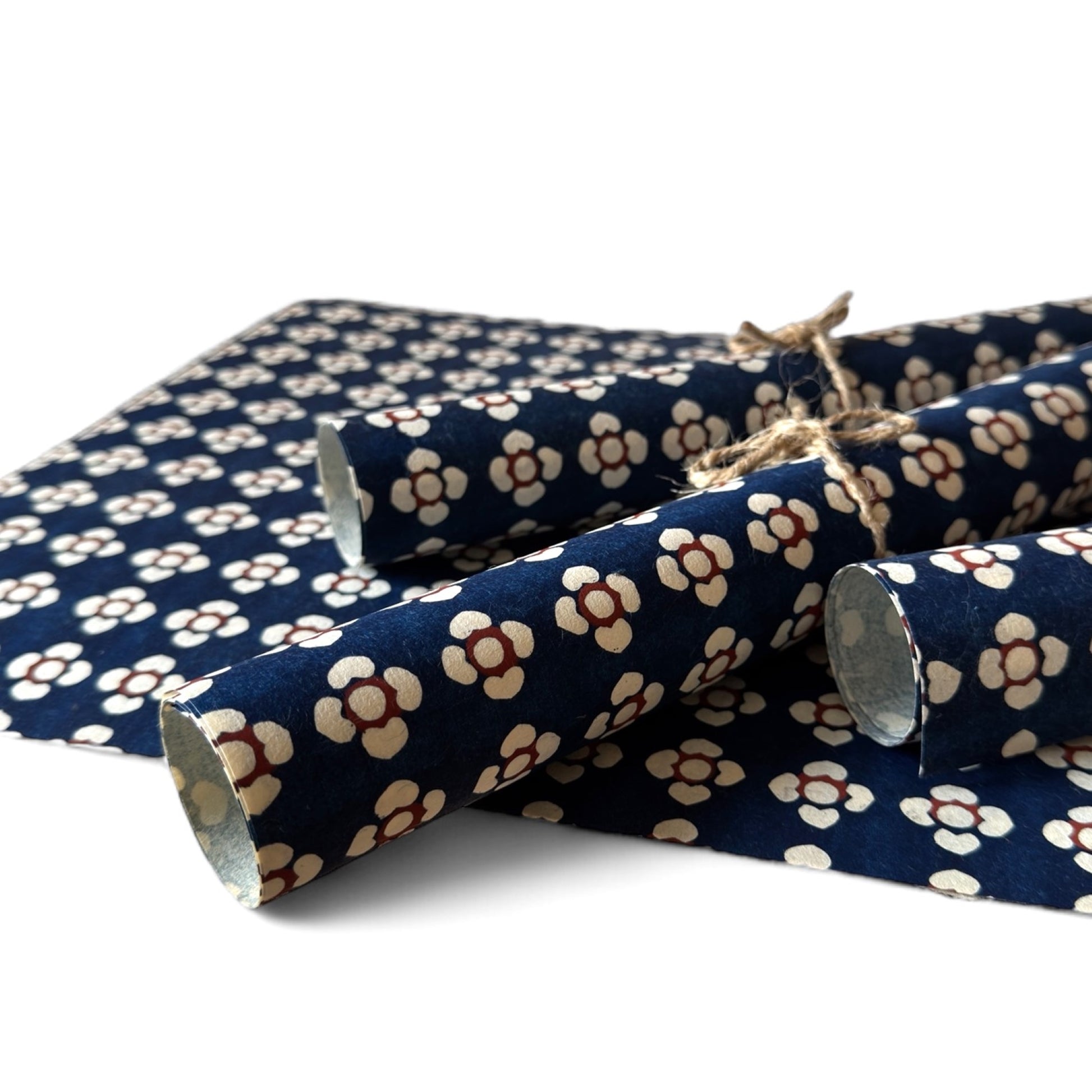 vintage katazome-shi stencil-dyed small papers from Japan. Navy paper with cream and red flower motif. Pictured rolled.
