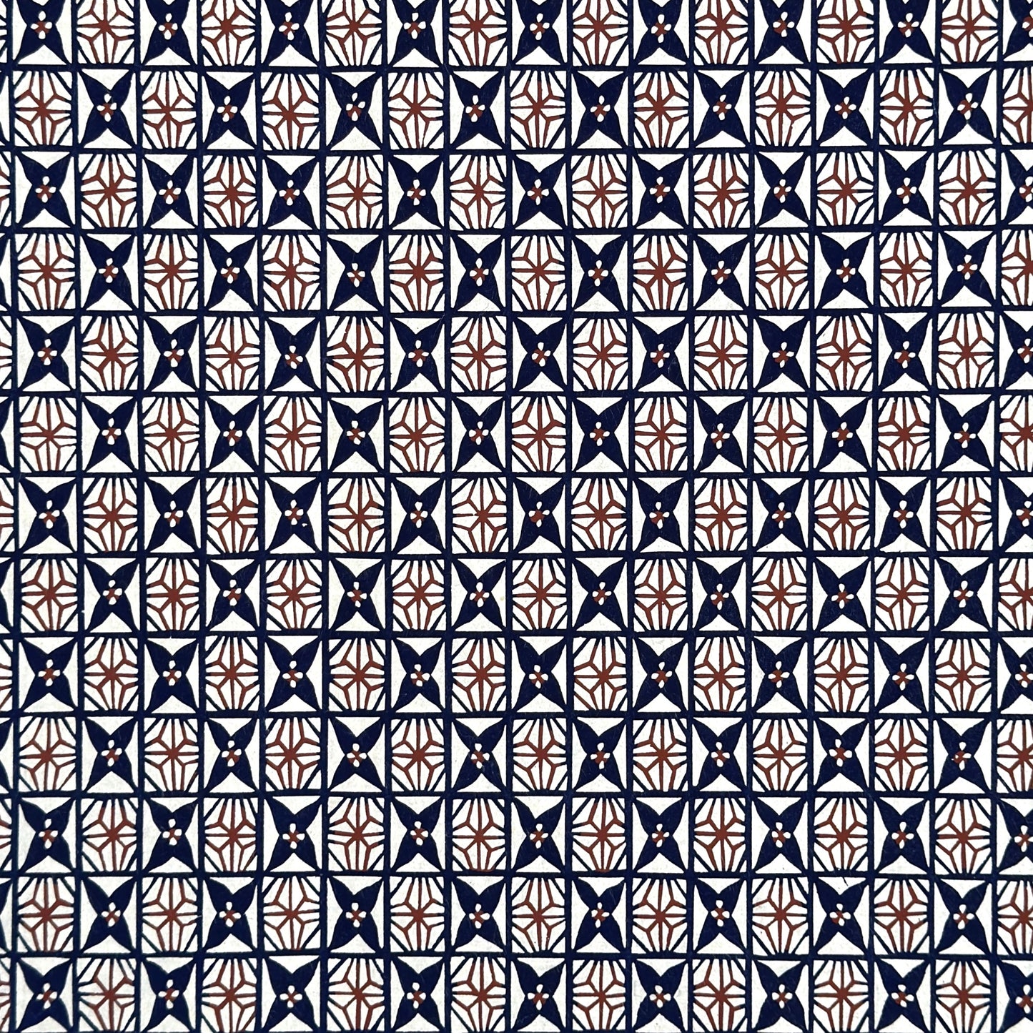 vintage katazome stencil dyed paper. Navy and red star pattern on cream paper.