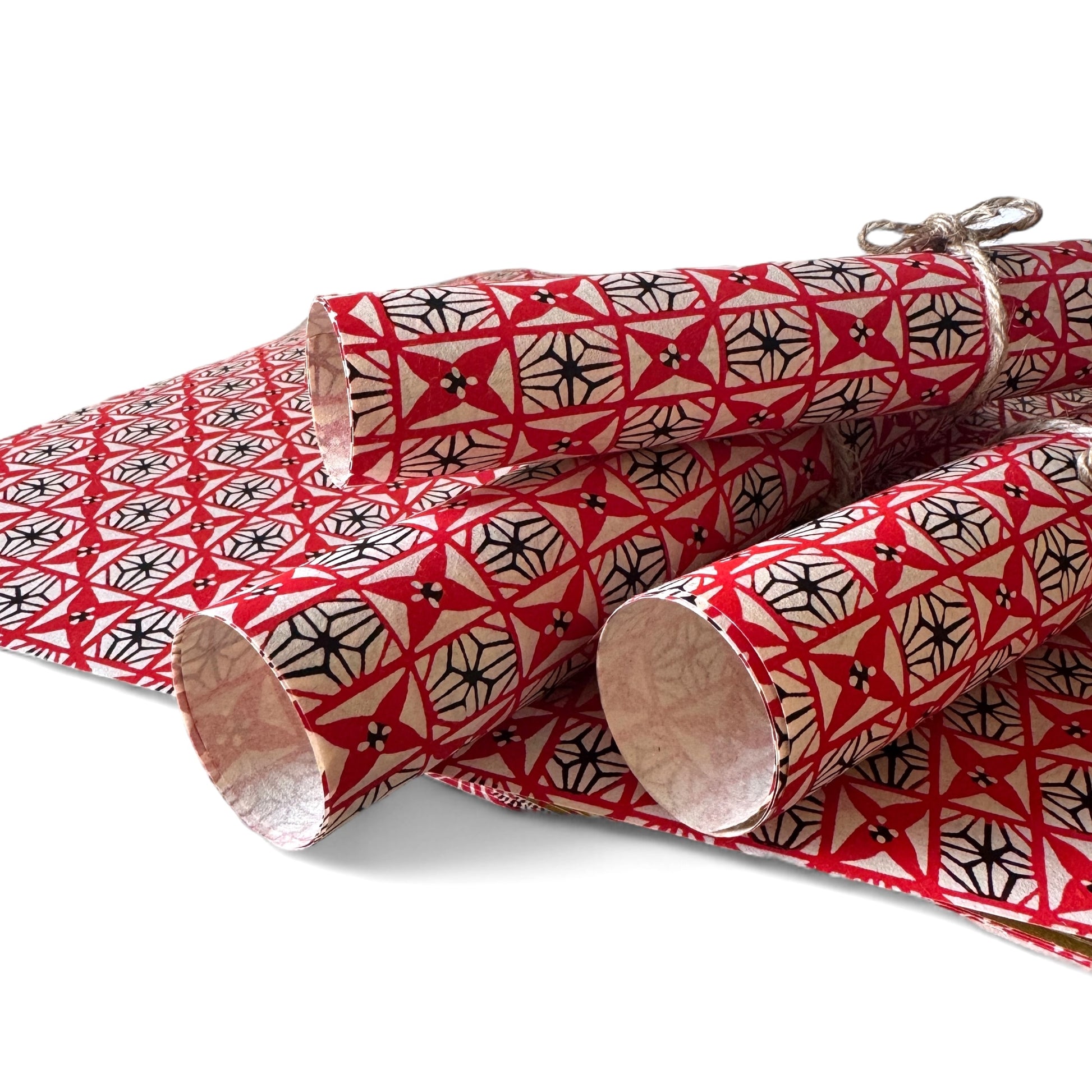 vintage katazome stencil dyed paper. Red and black star pattern on cream paper. Pictured rolled