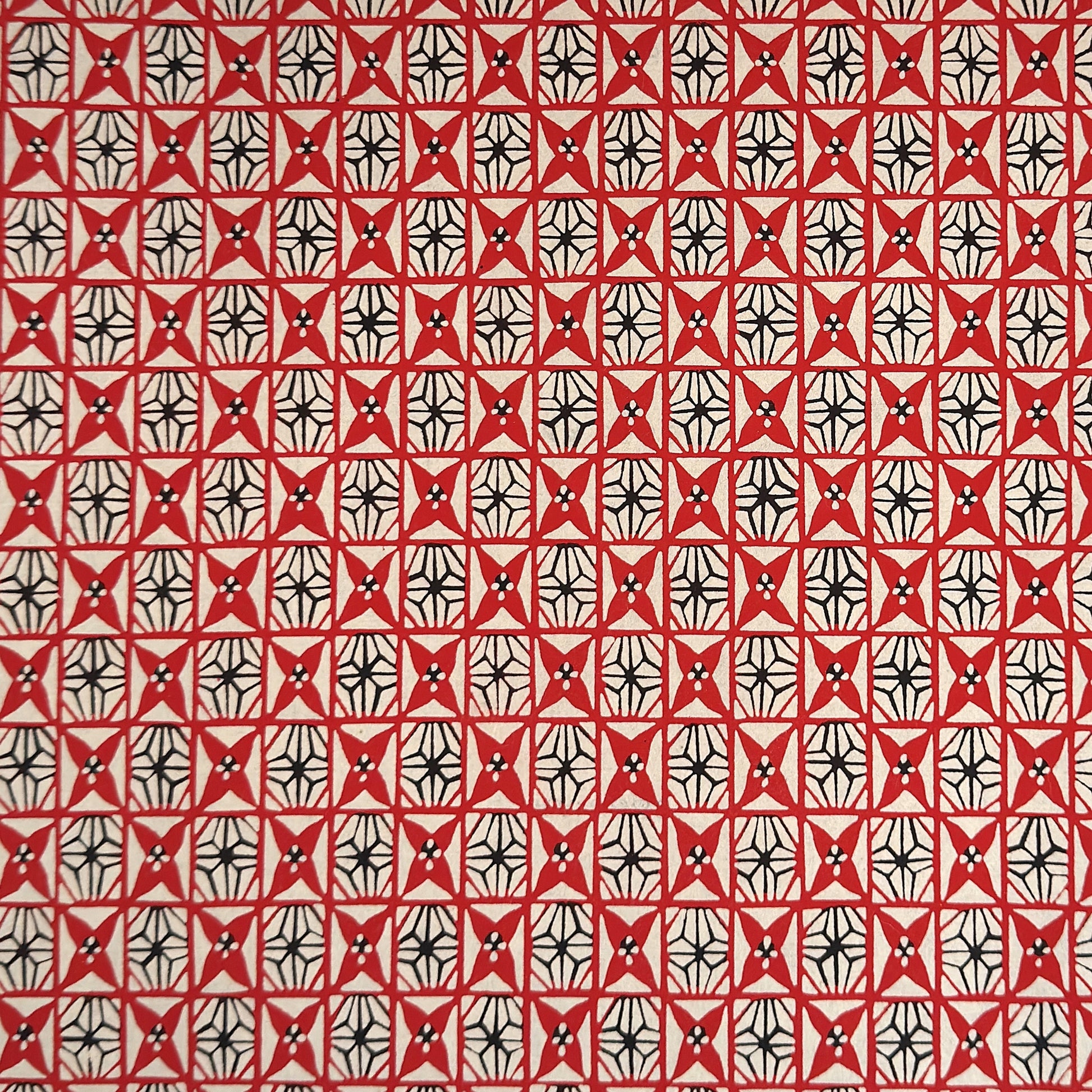 vintage katazome stencil dyed paper. Red and black star pattern on cream paper.
