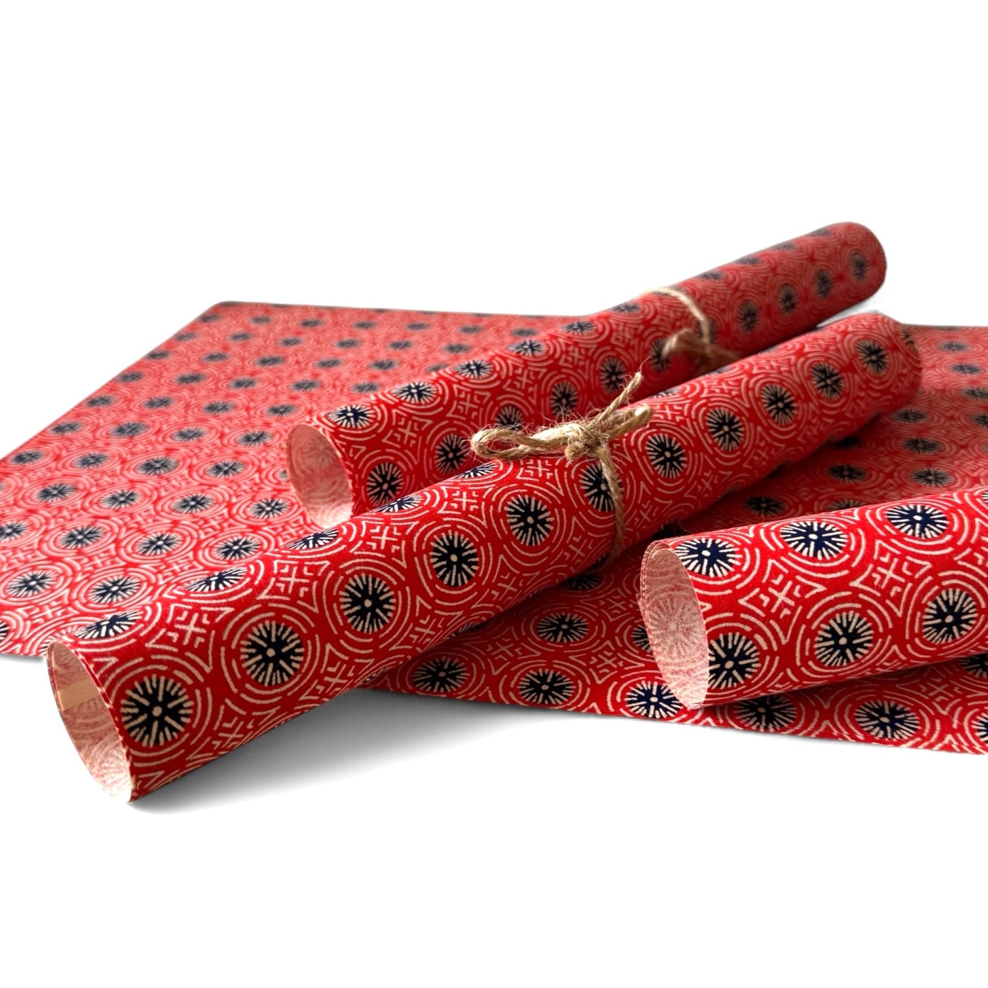 vintage katazome stencil dyed paper. red geometric design with dark blue circles and white lines.  Pictured rolled