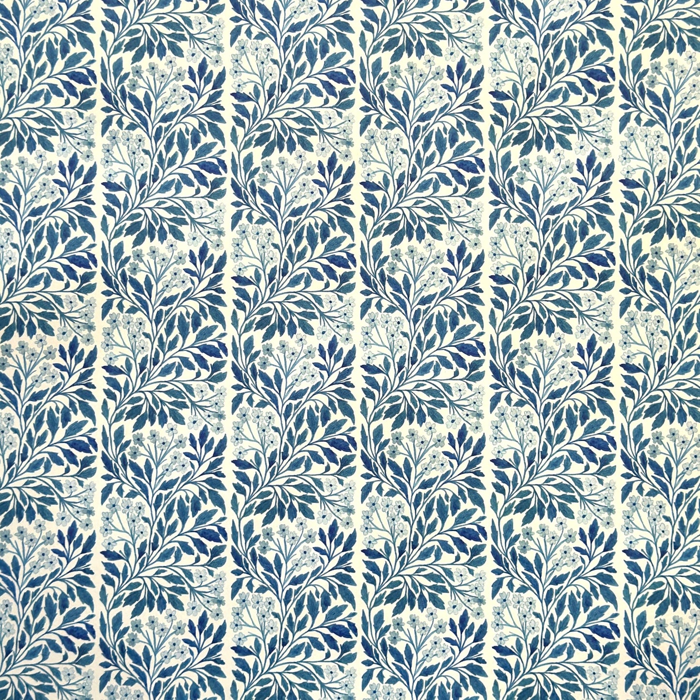patterned paper / gift wrap with a delicate floral repeat pattern in blue on a ivory background. By Wanderlust