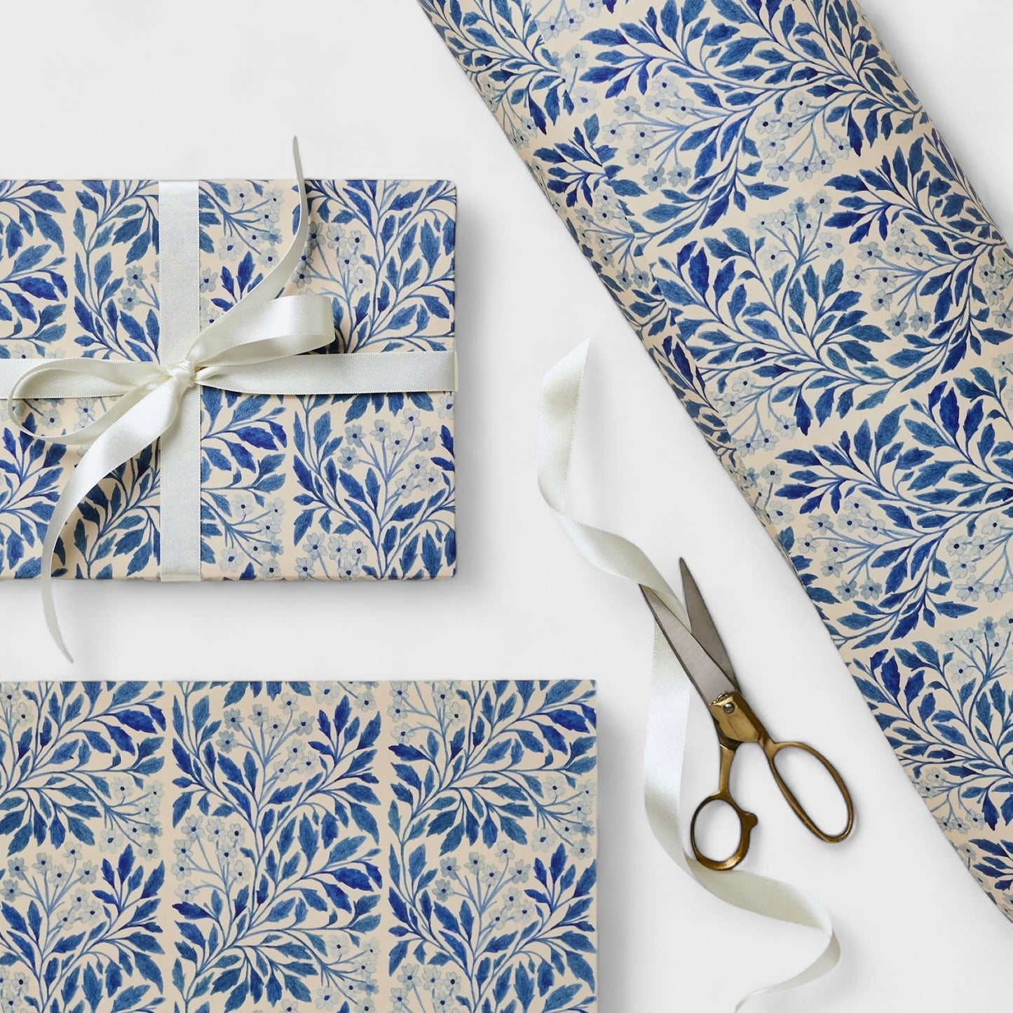 patterned paper / gift wrap with a delicate floral repeat pattern in blue on a ivory background. By Wanderlust. Pictured wrapped