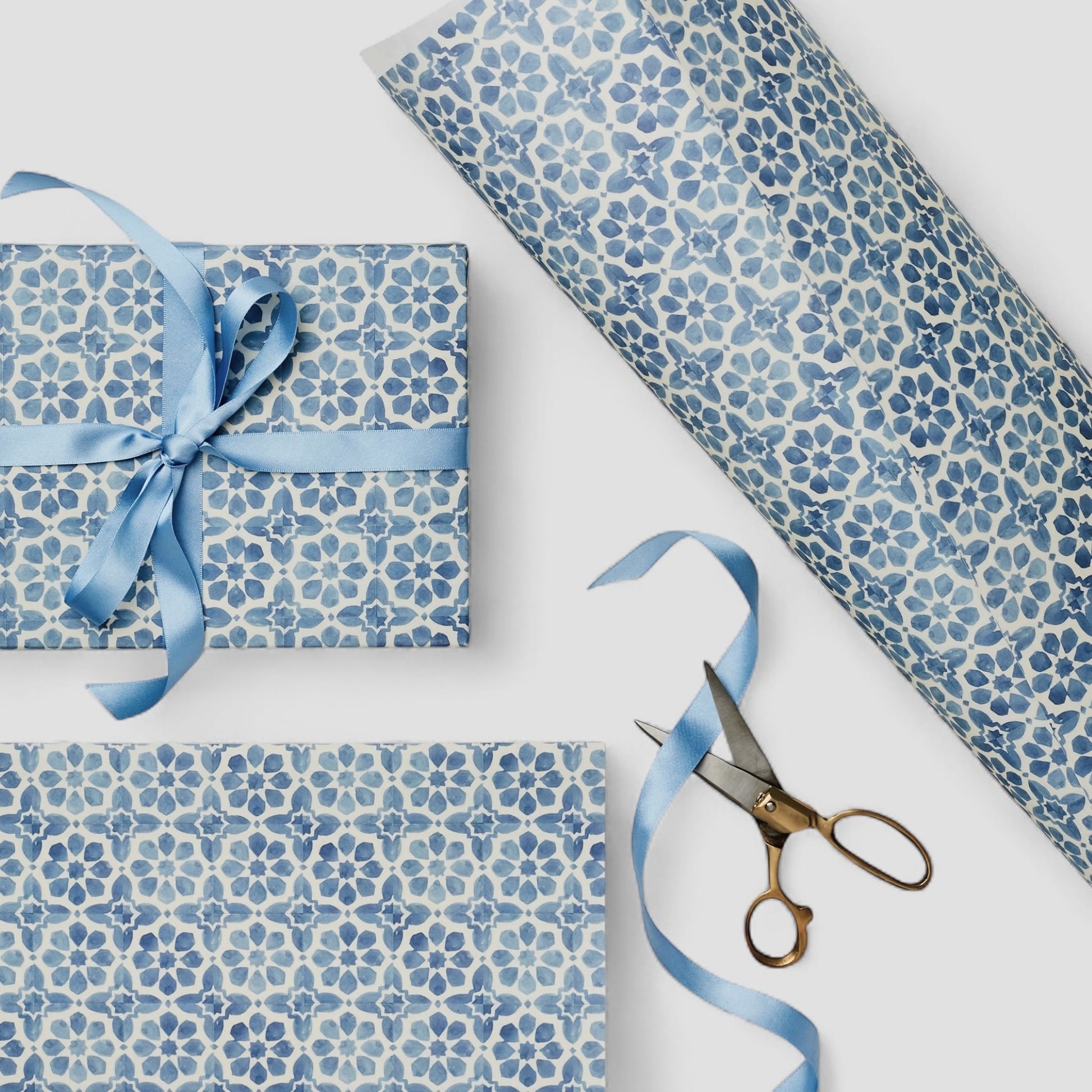 patterned paper / gift wrap with a blue and white tile design. By Wanderlust.  Pictured wrapped as a present