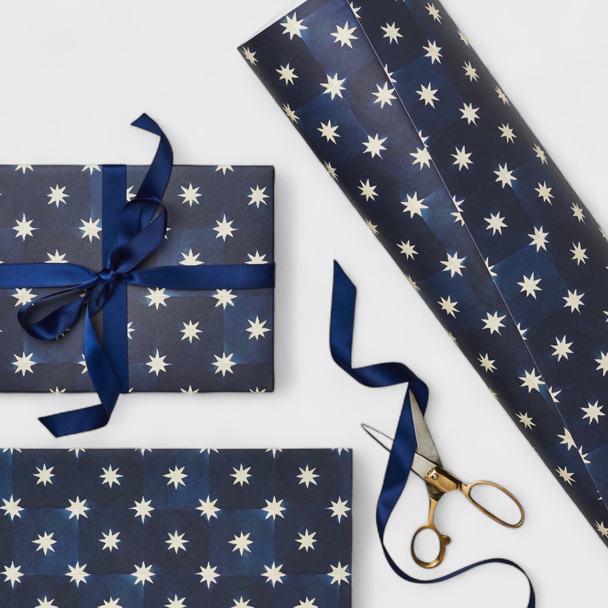 chequered navy blue with cream stars patterned wrapping paper. Pictured wrapped