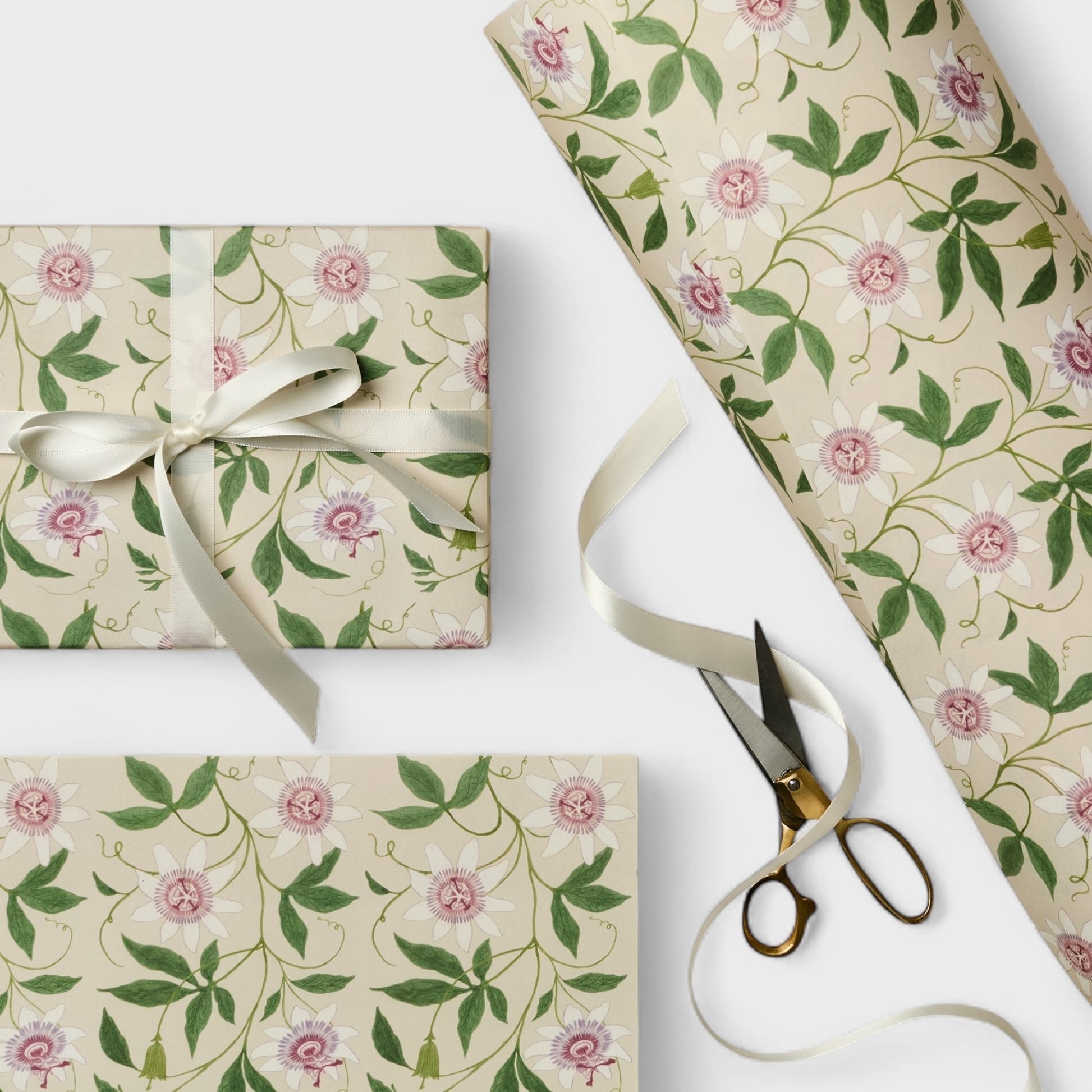 floral wrapping paper with pink passion flowers, green leaves on a cream background. Pictured wrapped