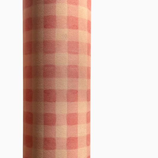Checkered pattern wrapping paper with pink and beige squares. Close up