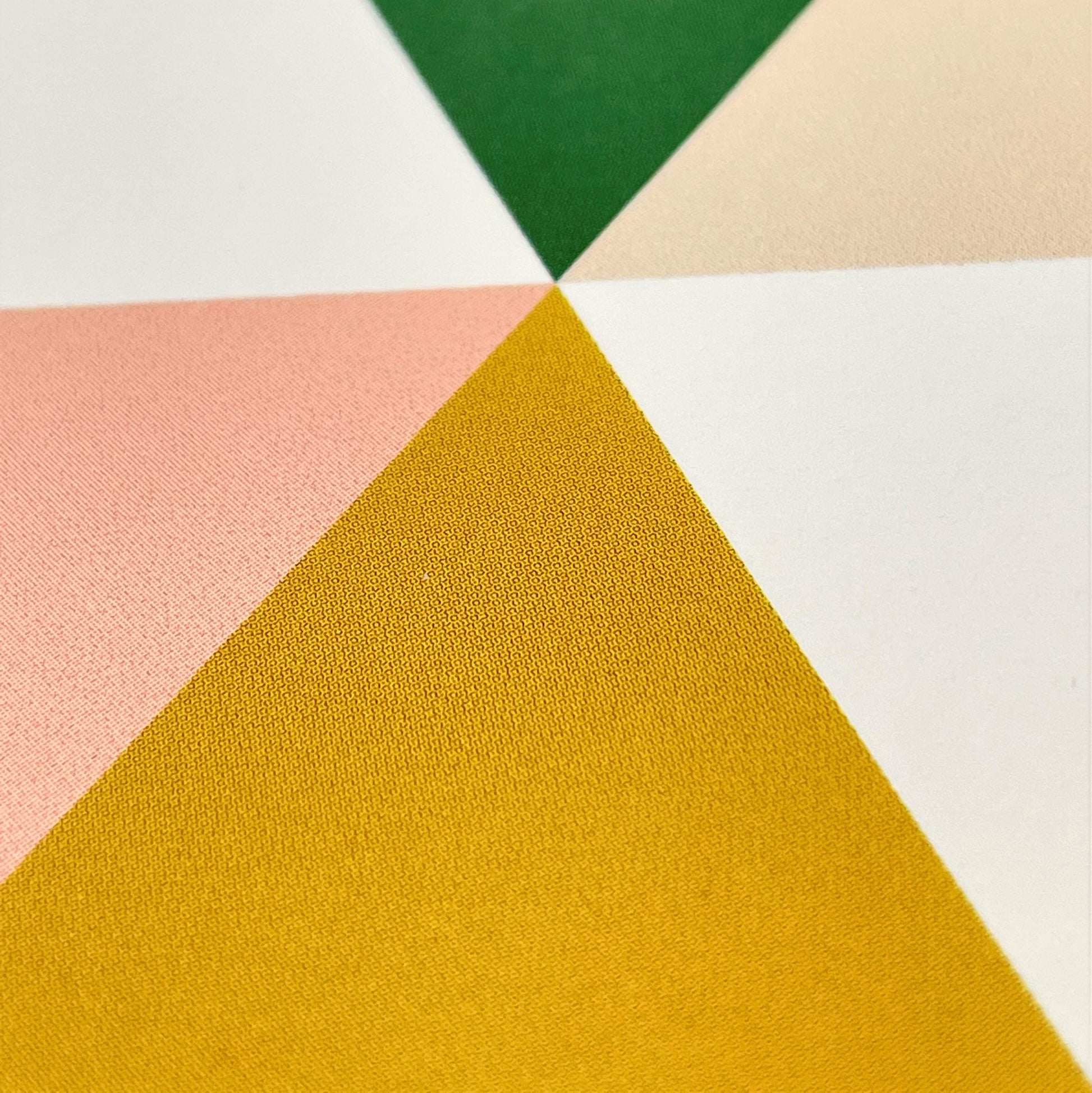 Greeting card with green, mustard, pink abstract triangles, close up of card