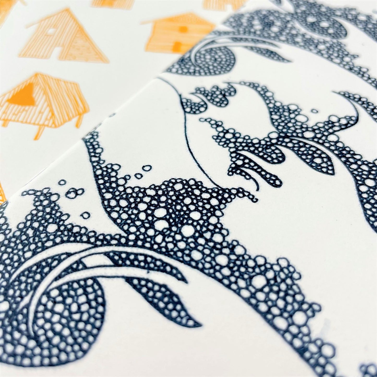 A5 slimline notebook with a delicate illustration of waves in dark blue on a ivory backdrop, close-up