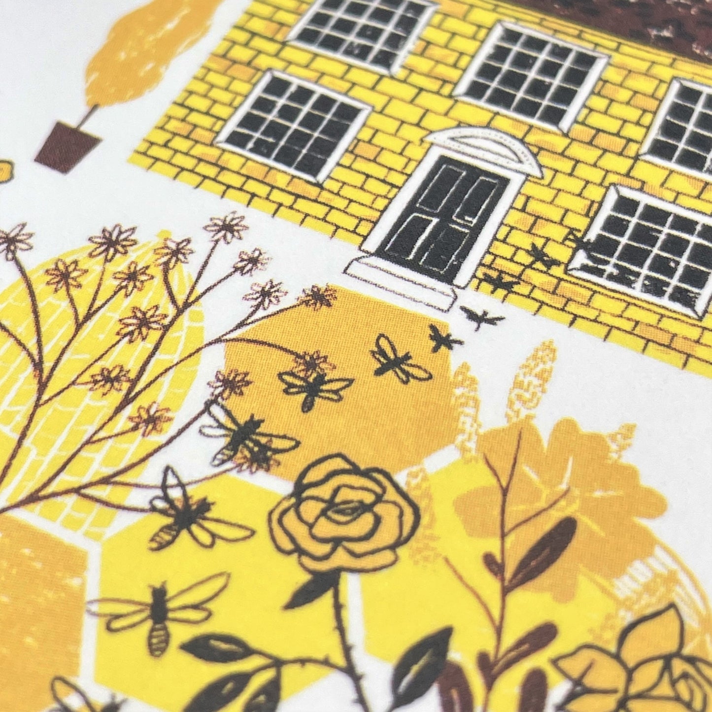 greetings card with a beekeeper and bee hive in a yellow painted garden, close up of the card