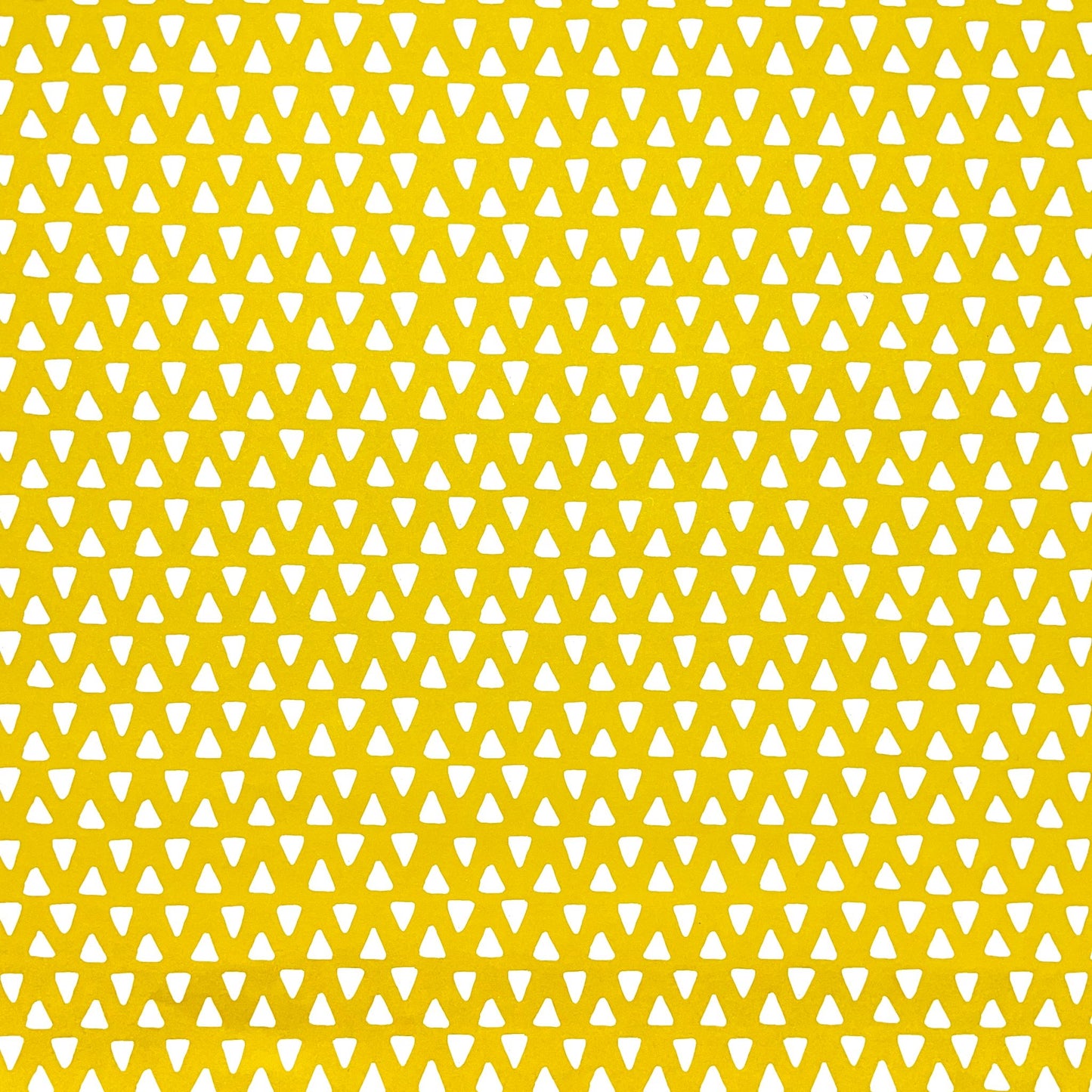 wrapping paper with yellow background and repeat pattern of little white triangles by Heather Evelyn