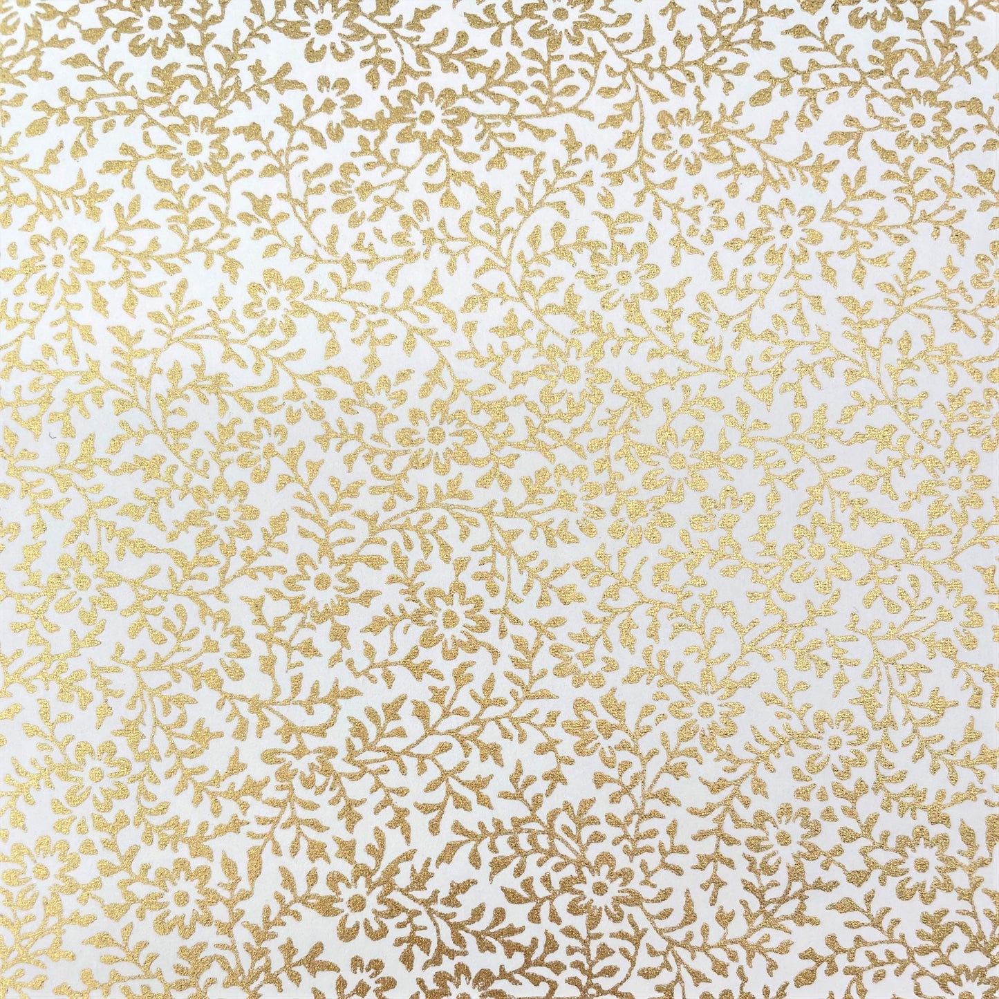 japanese silk-screen handmade paper showing a dainty gold botanical repeat design on ivory backdrop