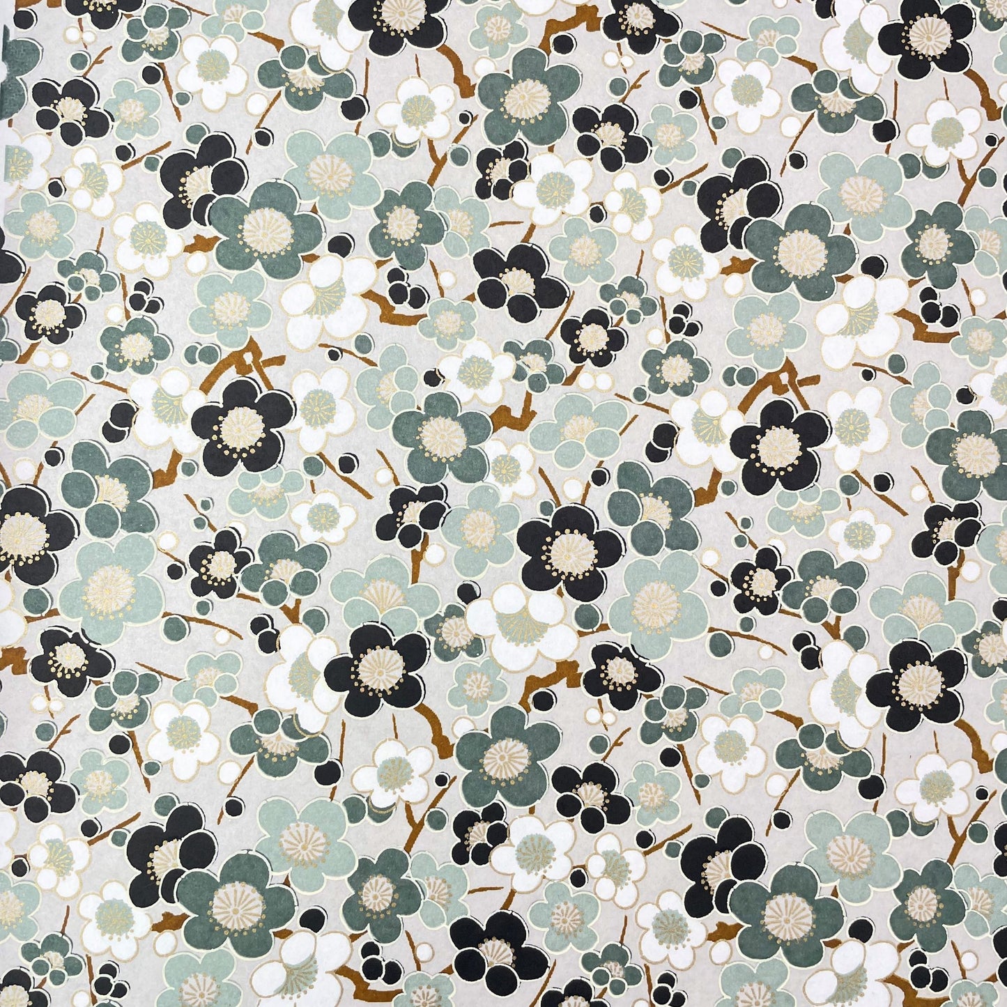 japanese silk-screen handmade paper showing soft green plum flower repeat pattern with gold highlights