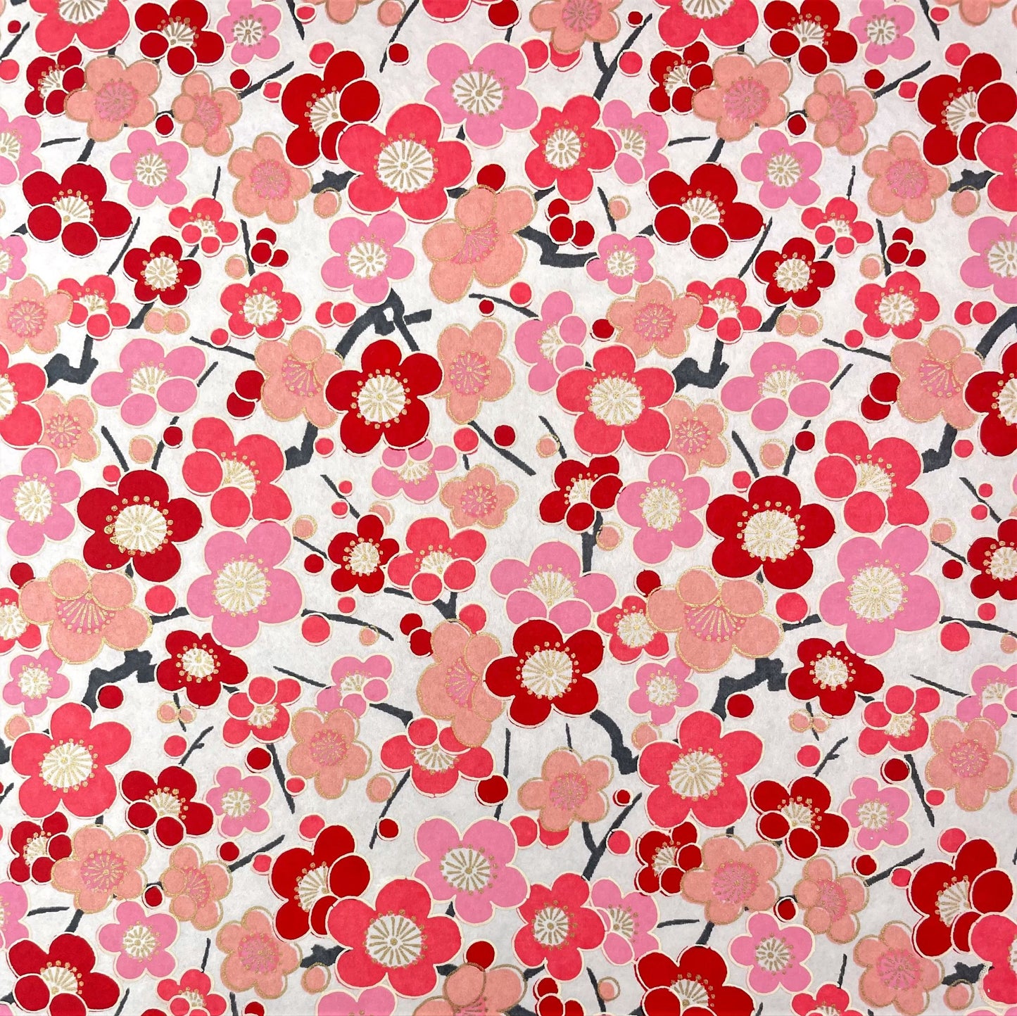 japanese silk-screen handmade paper showing pink and red plum flower repeat pattern with gold highlights