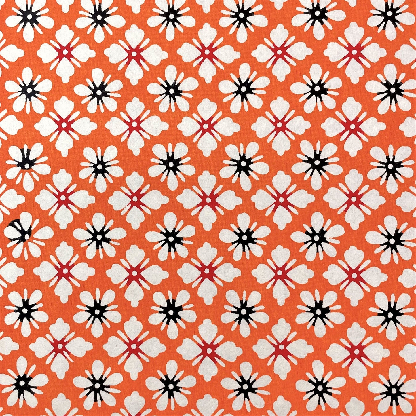 japanese stencil-dyed handmade paper with small scale floral repeat in orange and cream