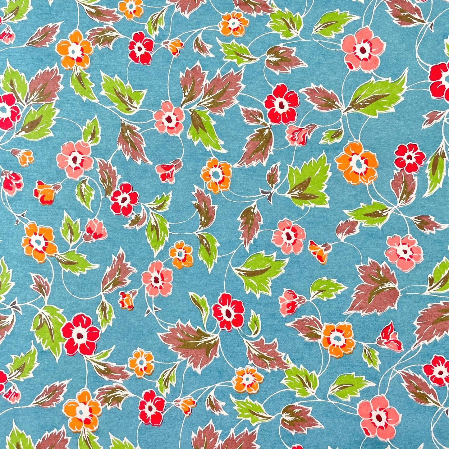 japanese stencil-dyed handmade paper with delicate repeat multi colour floral pattern on blue backdrop