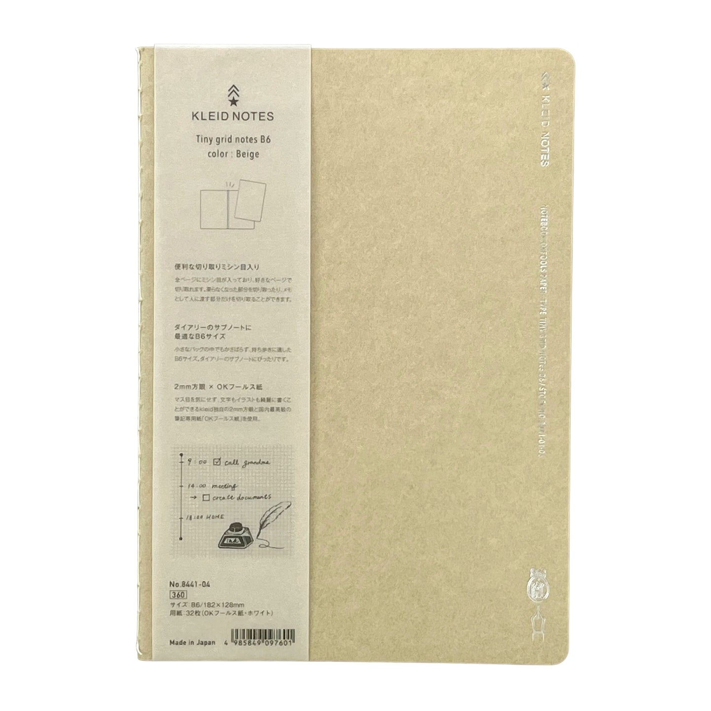 Soft cover notebook with grid format pages. Cover is plain beige with branded belly band