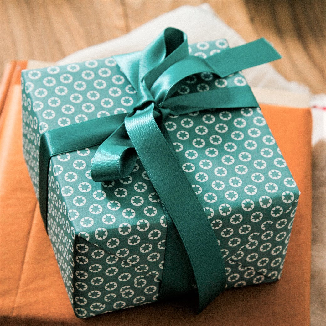 wrapping paper with an abstract tiny stars pattern in ice blue and white, wrapped with bow