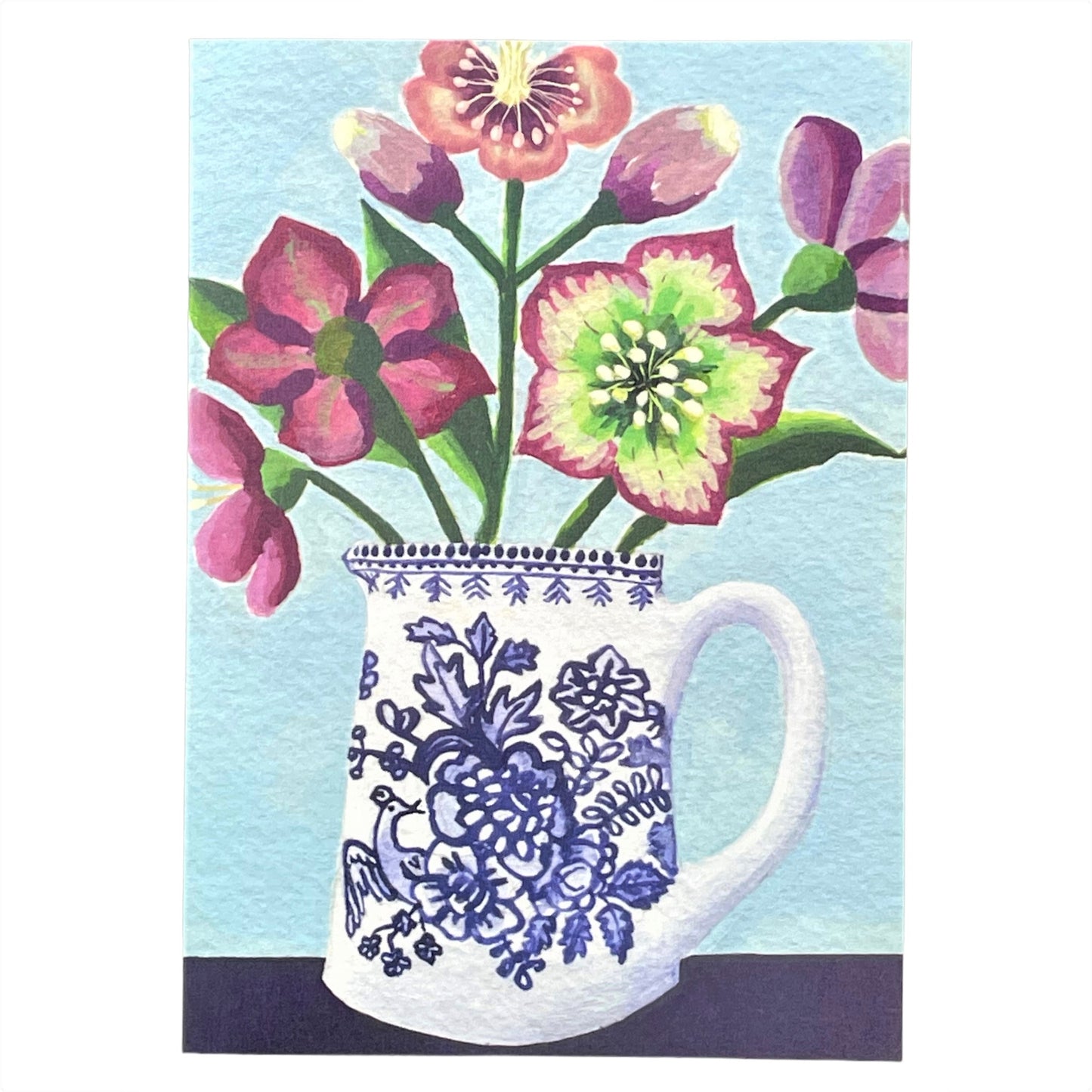 greeting card of a painting of purple hellebores in a blue and white patterned jug, with a pale blue background by Susie Hamilton