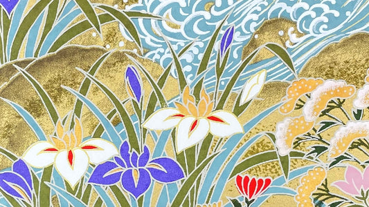 close up of a sheet of Japanese chiyogami washi patterned paper.  Image shows flowers near water in soft tones of lilac, sage, duck egg blue and gold.