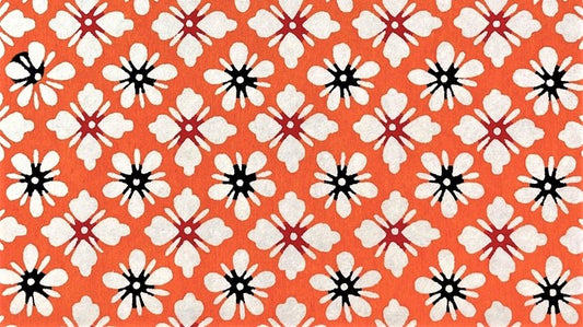 Image of a Japanese stencil-dyed handmade paper, with small repeat flower pattern in orange white and black