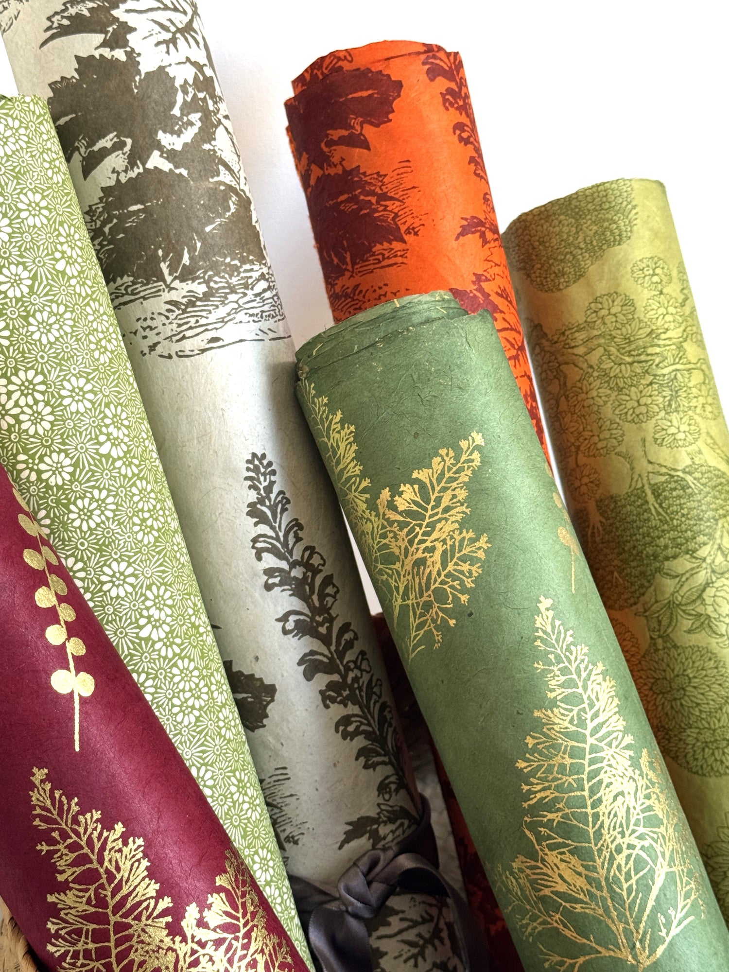 rolled Nepalese lokta papers in shades of green and orange 