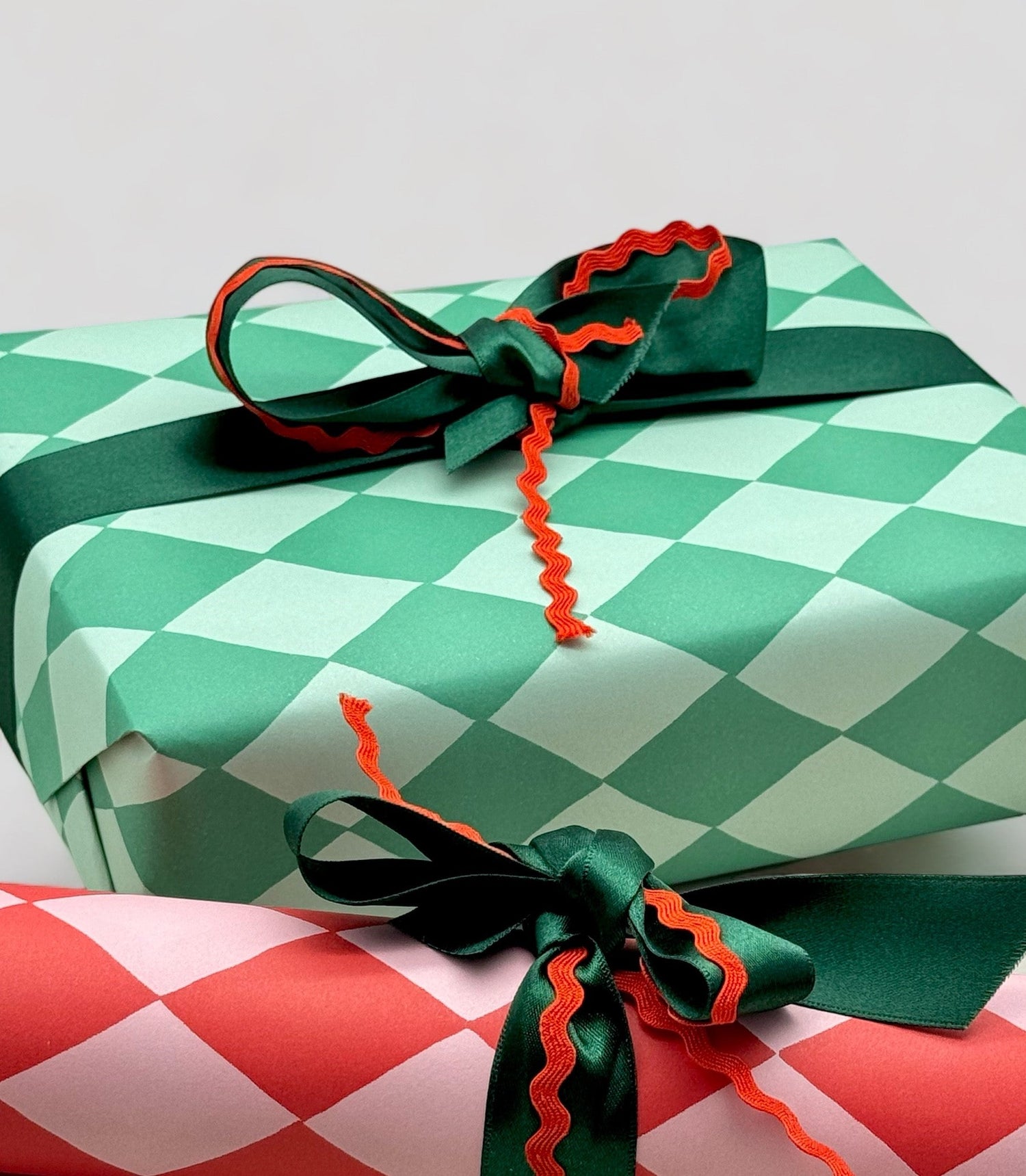 gifts wrapped in red and green diamond design wrapping paper with bows and ric rak