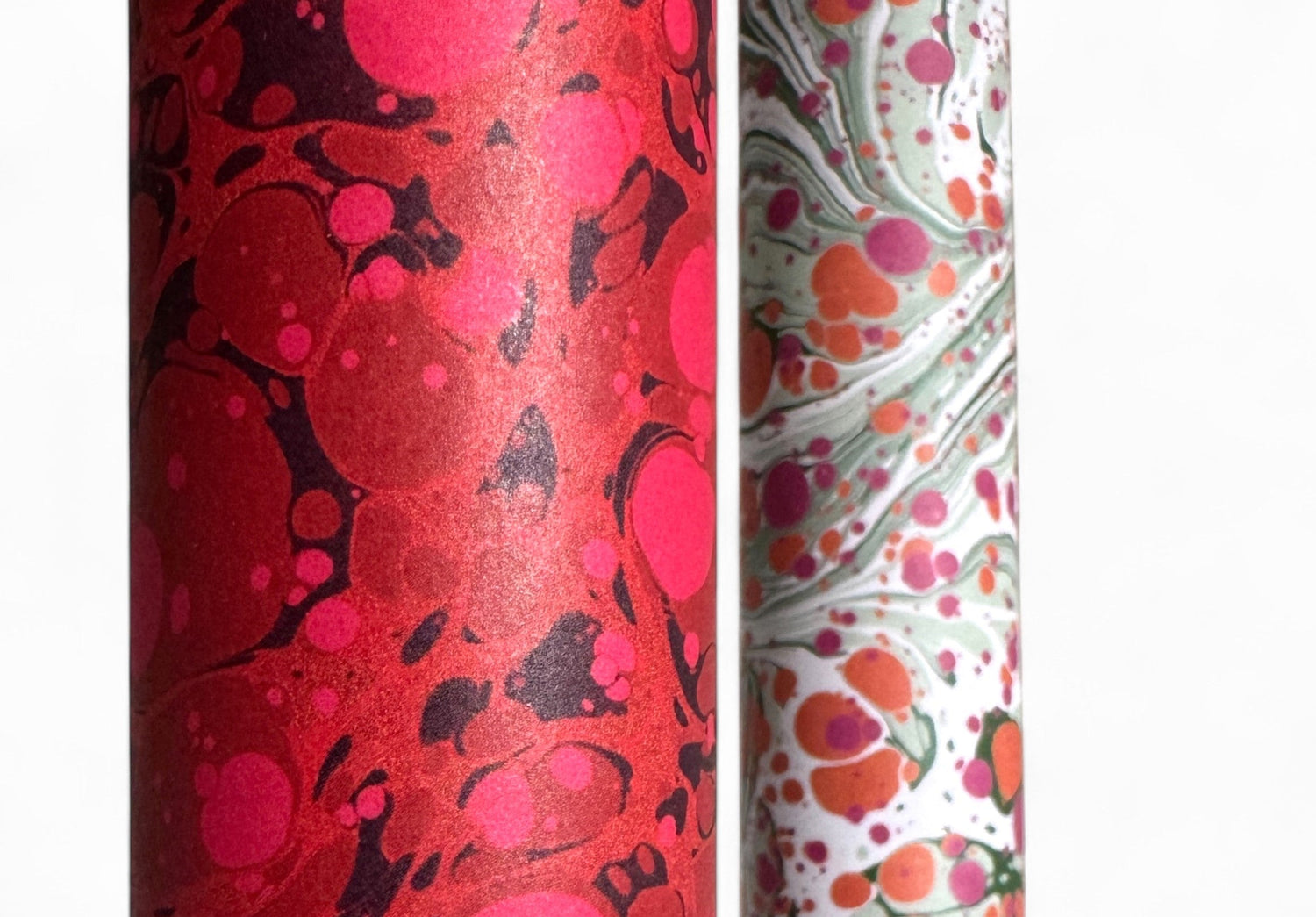 close up of rolls of printed marbled papers in deep red and pink