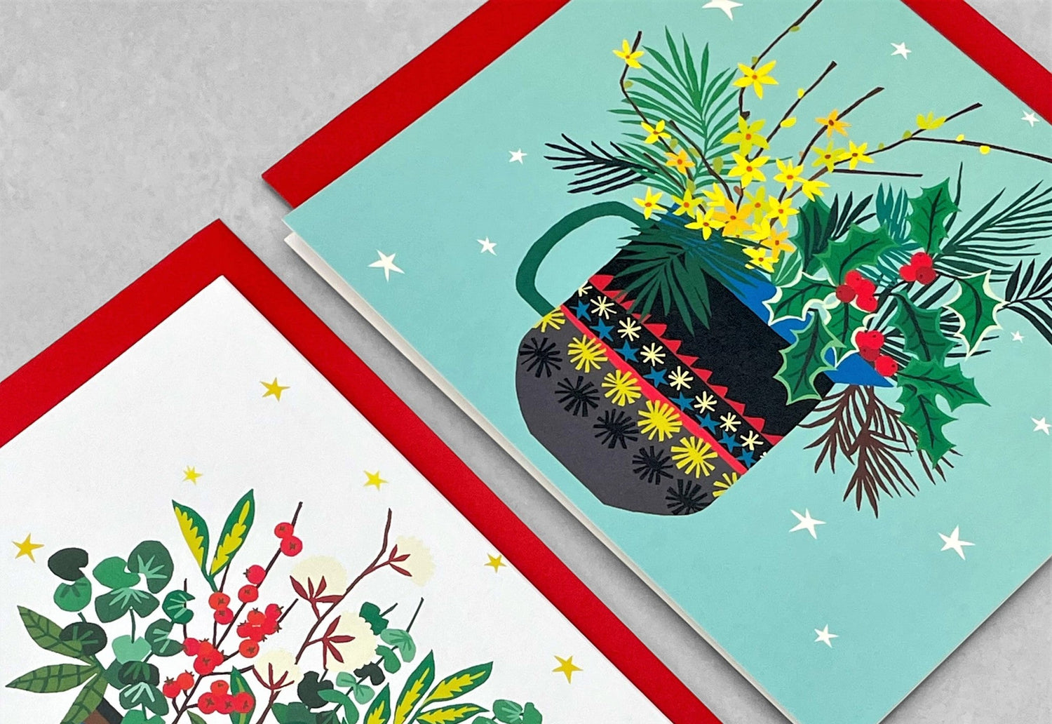 close up of a christmas card with a vase of festive foliage