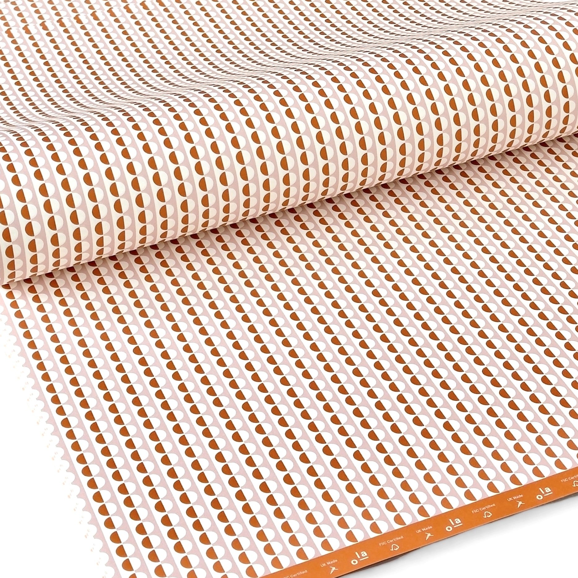 wrapping paper with an abstract circle pattern in orange and pale pink by Ola Studio