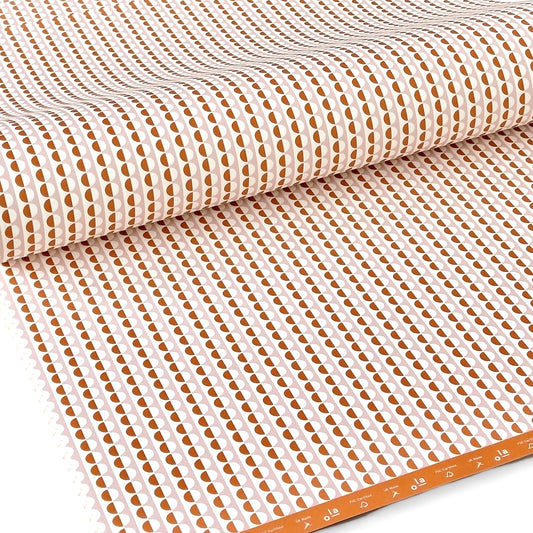 wrapping paper with an abstract circle pattern in orange and pale pink by Ola Studio