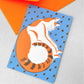 Greetings card of a sleeping cat, painted in blue and orange, by Ariana Martin